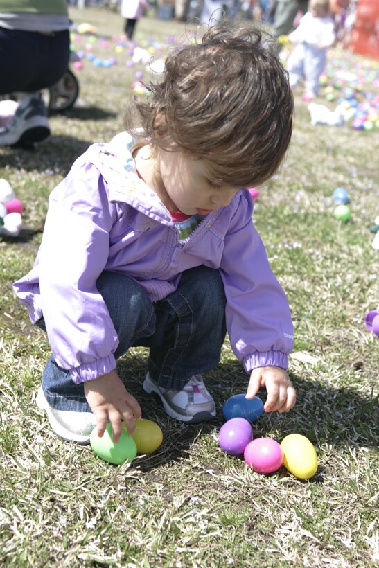 A young girl reaches down to pick up eggs at the 2010 Eggstravaganza egg hunt.  Along with the egg hunt, families in attendance also got to enjoy a number of arts, crafts and a free hotdog lunch.