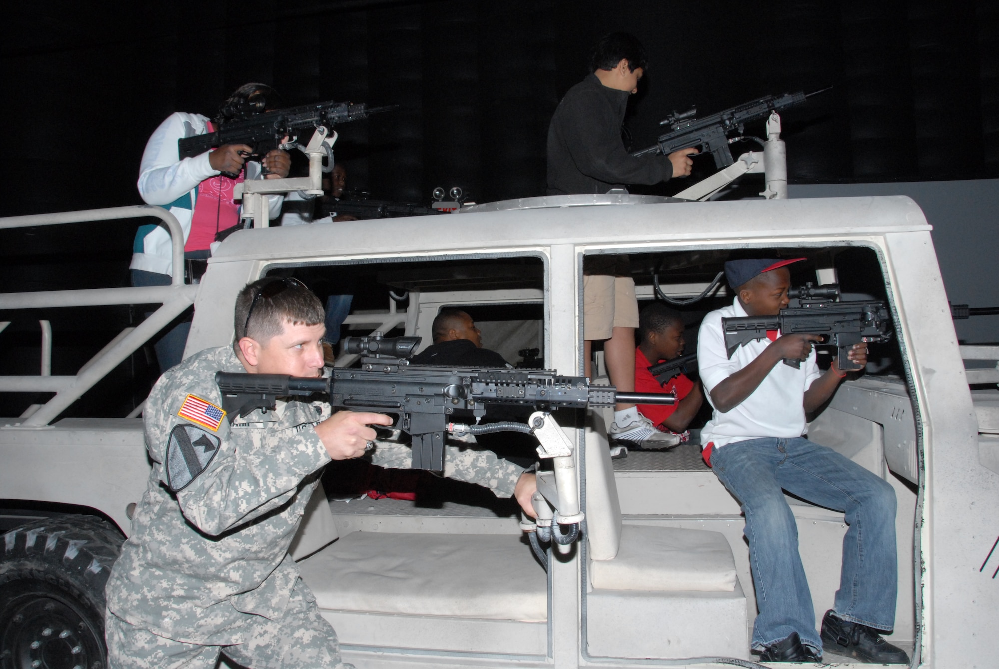 A soldier and several air show visitors participate in the Virtual Army Experience at the Thunder Over Alabama air show March 27, 2010. The Maxwell Air Force Base, Ala. air show is celebrating 100 years of flight over Alabama. (U.S. Air Force photo/Bennett Rock)