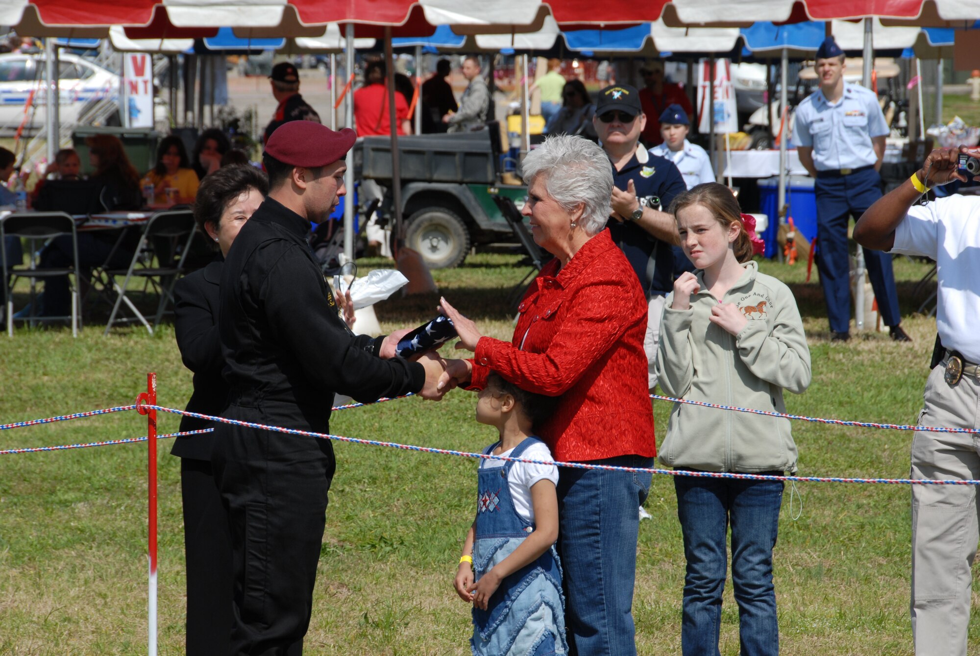 The U.S. Army Golden Knights hand a flag to the mother of a deployed Airman from Maxwell Air Force Base, Ala. during the Thunder Over Alabama air show here March 27, 2010. The Maxwell Open House and Air Show is celebrating 100 years of flight over Alabama. (U.S. Air Force photo/Bennett Rock)