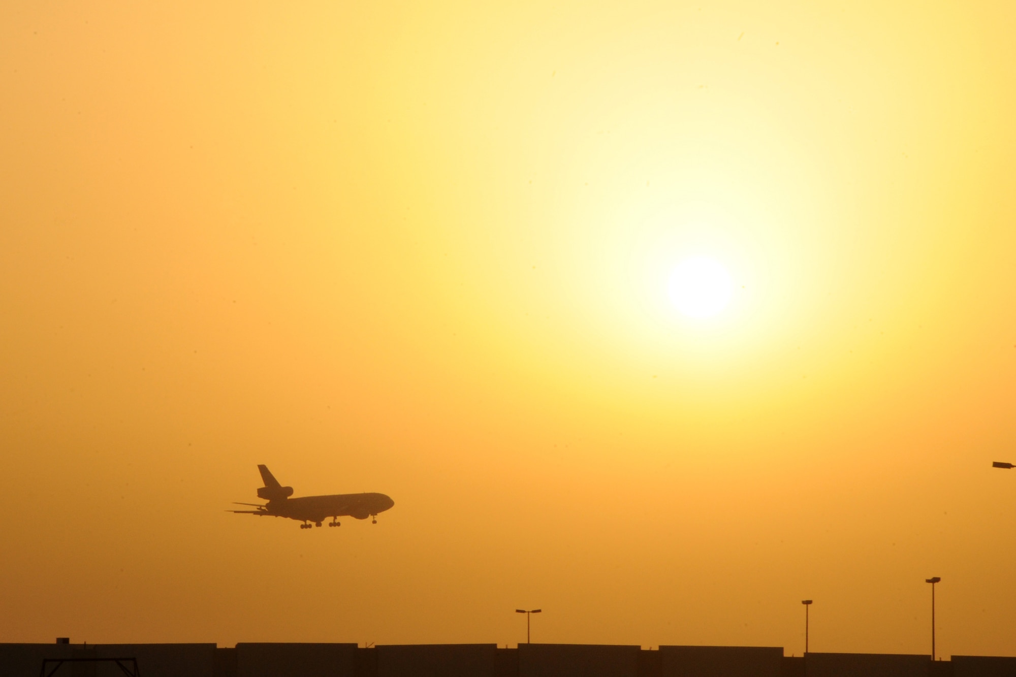 A KC-10 Extender lands as the suns sets over the 380th Air Expeditionary Wing at an undisclosed location in Southwest Asia on March 25, 2010. The 380th Air Expeditionary Wing, supports operations Iraqi Freedom and Enduring Freedom and the Combined Joint Task Force-Horn of Africa. The 380th AEW is comprised of four groups and 12 squadrons and the wing's deployed mission includes air refueling, surveillance and reconnaissance in support of overseas contingency operations in Southwest Asia. (U.S. Air Force photo/Senior Airman Jenifer H. Calhoun/Released)
