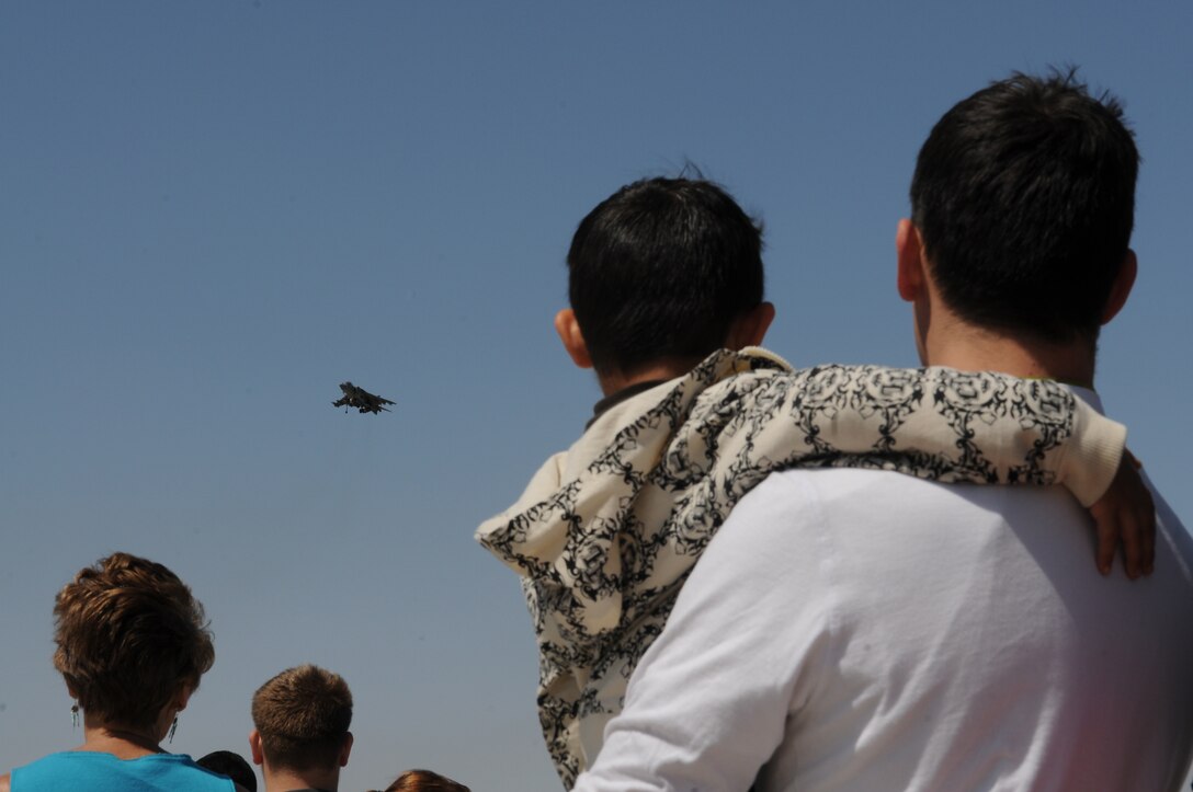 Trevor Bannings Sr. and his son Trevor Bannings Jr., 5, watch as a Marine Corps AV-8B Harrier makes its trademark vertical landing during the 2010 Yuma Air Show March 27, 2010, at the Marine Corps Air Station in Yuma Ariz. "It's simply amazing the kinds of things the Harriers can do," said Bennings Sr. The 48th annual air show drew approximately 20,000 spectators and featured 50 static displays.