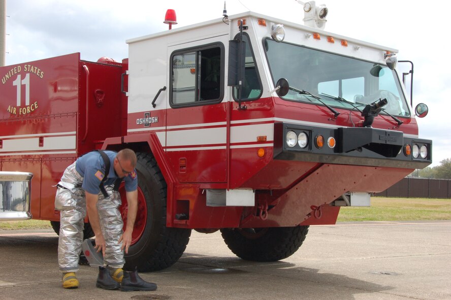 Christopher Taylor, a firefighter with the Maxwell-Gunter Fire Department, gears up to respond to a small grass fire March 28 during the Thunder Over Alabama air show at Maxwell Air Force Base, Ala. (U.S. Air Force photo/Airman 1st Class Christopher S. Stoltz)