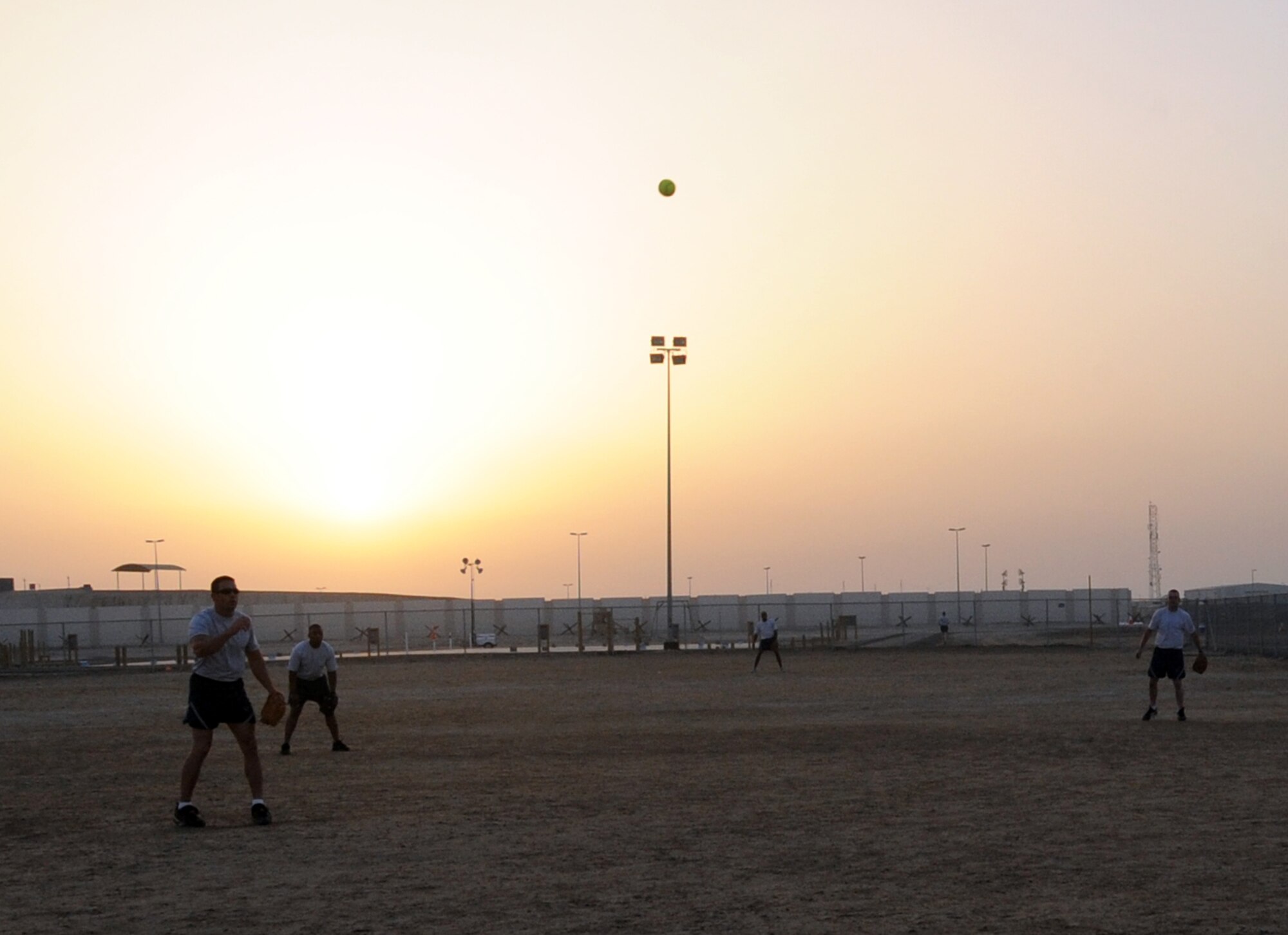 Airmen from the 380th Air Expeditionary Wing play a game of softball on a sand field at a non-disclosed base in Southwest Asia on March 25, 2010.  (U.S. Air Force Photo/Senior Airman Jenifer H. Calhoun/Released)