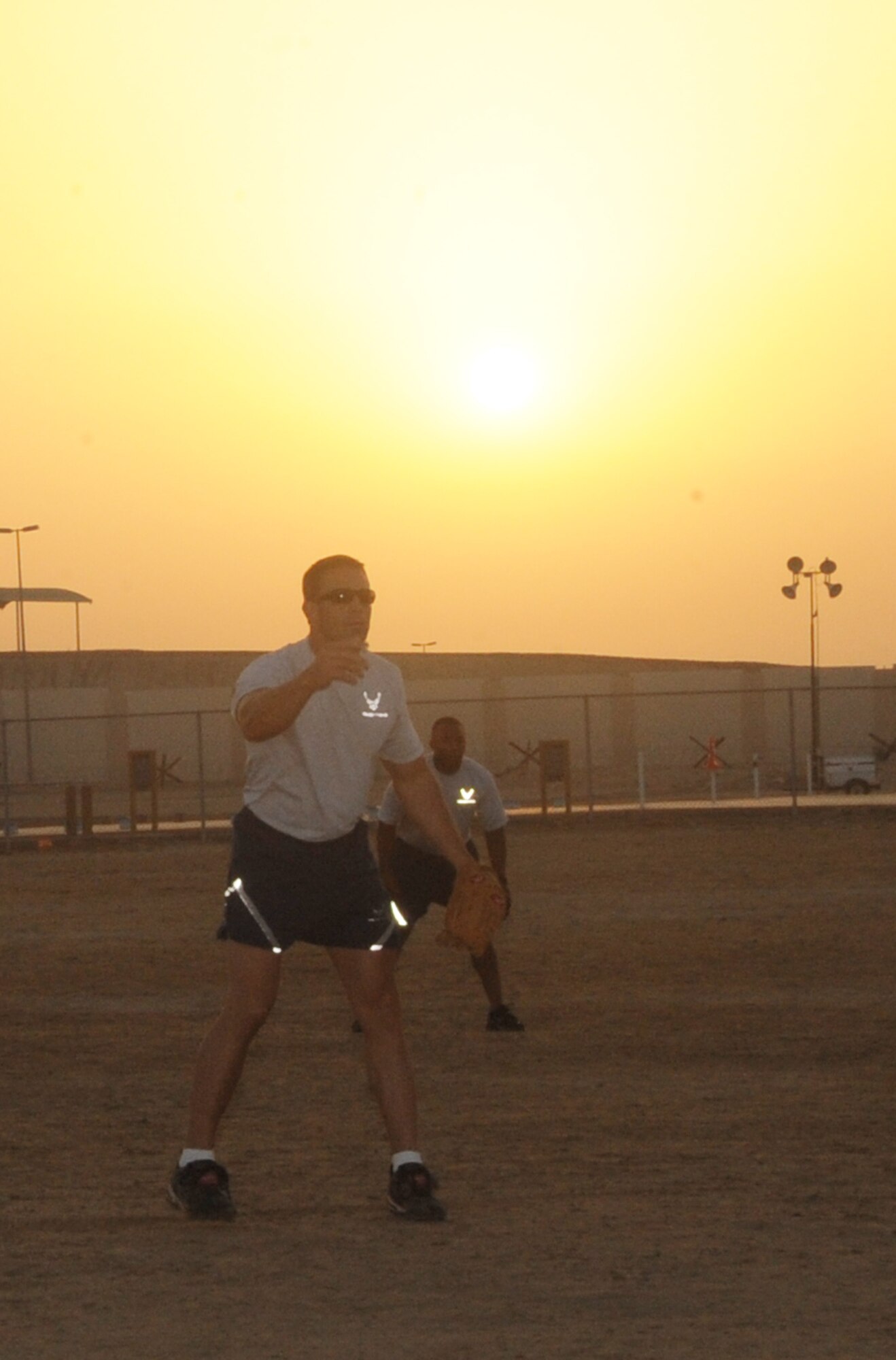 Airmen from the 380th Air Expeditionary Wing play a game of softball on a sand field at a non-disclosed base in Southwest Asia on March 25, 2010.  (U.S. Air Force Photo/Senior Airman Jenifer H. Calhoun/Released)