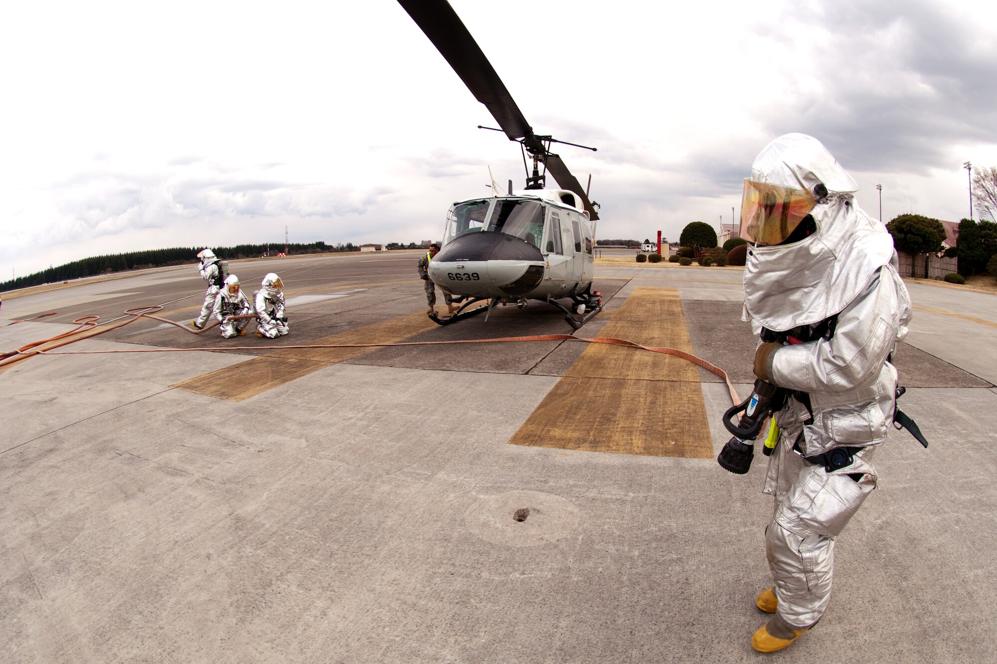 YOKOTA AIR BASE, Japan -- Yokota firefighters prepare to battle a fire during a simulated UH-1 Huey egress and fire here March 29. The exercise tested Yokota Airmen's operational readiness preparedness. (U.S. Air Force photo/Osakabe Yasuo)