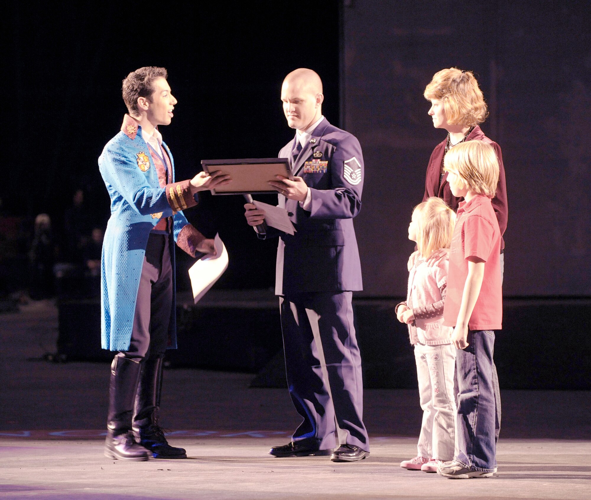 Master Sgt. Cameron Rogers, along with his wife Maggie and children Sam and Laine, receive a certificate from Magical Zingmaster Alex Ramon designating the Rogers family as guest ringmasters for the Ringling Bros. and Barnum & Bailey "Zing Zang Zoom" circus performance March 26, 2010, at George Mason University's Patriot Center in Fairfax, Va.  Sergeant Rogers is the Air Force District of Washington's UH-1N helicopter program manager at Bolling Air Force Base, D,C, The Rogers family was invited to serve as guest circus ringmasters representing military families worldwide in observance of Year of the Air Force Family. (U.S. Air Force photo/Jim Varhegyi)