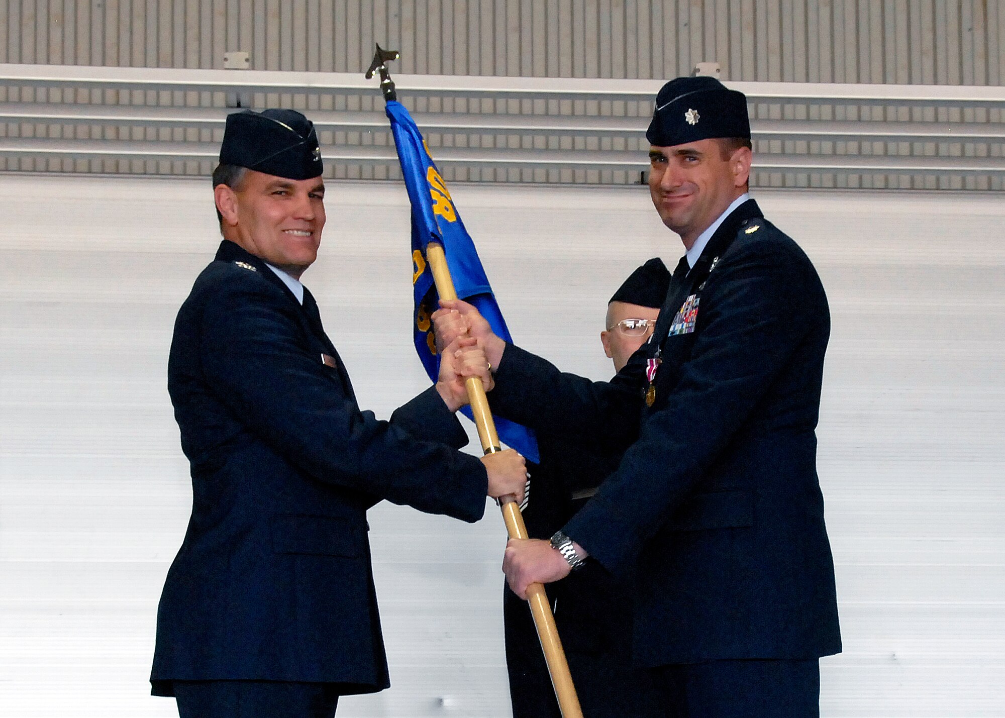 Lt. Col. Michael Messer (right), the outgoing 80th Operations Support Squadron commander, relinquishes command of the squadron to Col. Glen Lawson (left), 80th Operations Group deputy commander, March 26 during the squadron's change-of-command ceremony at Bldg. 2550 on Sheppard Air Force Base, Texas. Lt. Col. Barry Cook, incoming 80th OSS commander, assumes command. (U.S. Air Force photo/Mike Litteken)