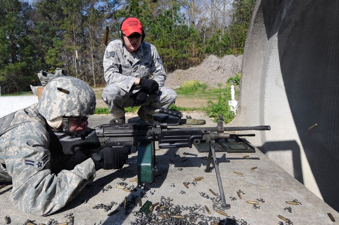 U.S. Air Force Airman 1st Class Christopher Duplisea fires an M249 machine gun while Staff Sgt. Jason Whisenhunt monitors at Joint Base Charleston, S.C., March 26, 2010. Airman Duplisea shot 600 rounds of ammunition in preparation for deployment along with fellow security forces members receiving weapons familiarization training. Sergeant Whisenhunt is a combat arms instructor, and Airman Duplisea is a patrolman. Both are with the 628th Security Forces Squadron. (U.S. Air Force photo by James M. Bowman/released)
