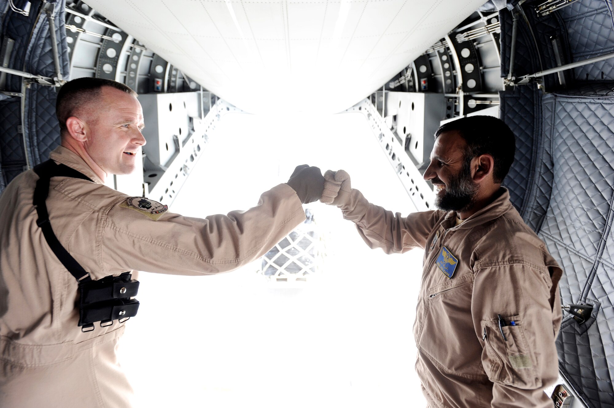Master Sgt. Chris Ringland and Afghanistan National Army Air Corps Master Sgt. Sheer Aqa Karimi congratulate each other after successfully unloading the missions cargo to its detestation March 28, 2010, at Camp Bastion, Afghanistan. Sergeant Karimi is a C-27 Spartan loadmaster, and Sergeant Ringland is a 438th Air Expeditionary Advisory Group standards and evaluation loadmaster. (U.S. Air Force photo/Staff Sgt. Manuel J. Martinez)
