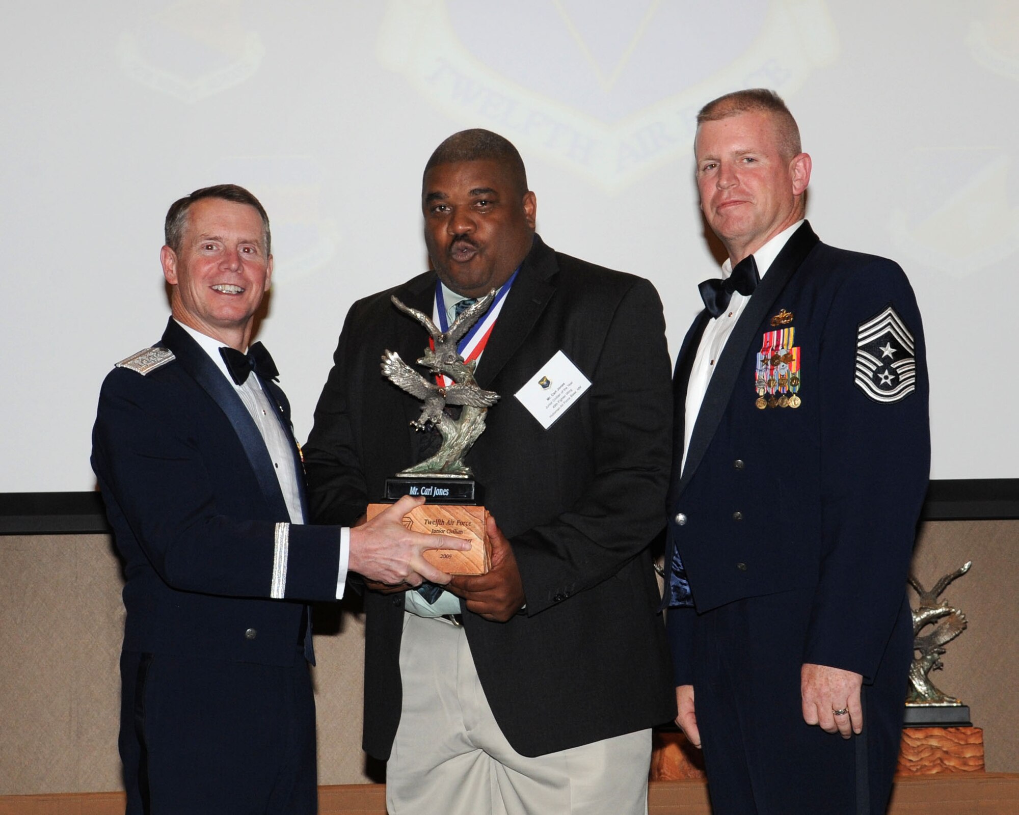 DAVIS-MONTHAN AIR FORCE BASE, Ariz. -- Lt. Gen. Glenn Spears (left), 12th Air Force (Air Forces Southern) commander, and Chief Master Sgt. Harold Clark (right), 12th AF (AFSOUTH) command chief, present the Outstanding Performer of the Year award to Mr. Carl Jones Mar. 9. Mr. Jones is from the 49th Fighter Wing, Holloman Air Force Base, N.M.  (U.S. Air Force Photo by Airman Jerilyn Quintanilla)