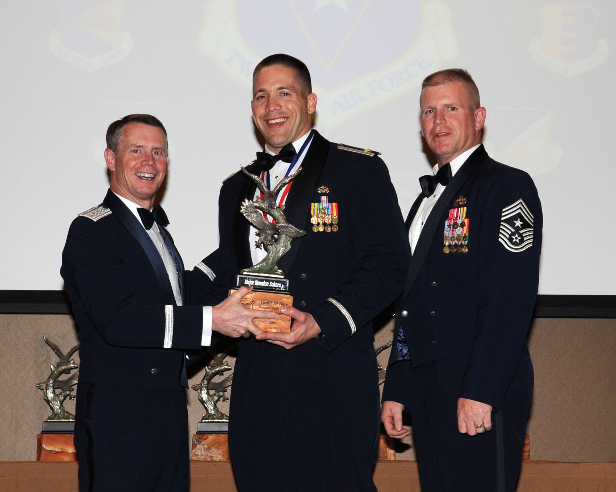 DAVIS-MONTHAN AIR FORCE BASE, Ariz. -- Lt. Gen. Glenn Spears (left), 12th Air Force (Air Forces Southern) commander, and Chief Master Sgt. Harold Clark (right), 12th AF (AFSOUTH) command chief, present the Outstanding Performer of the Year award to Maj. Brandon Sokora Mar. 9. Major Sokora is from the 820th Red Horse Squadron, Nellis Air Force Base, Nev.  (U.S. Air Force Photo by Airman Jerilyn Quintanilla)