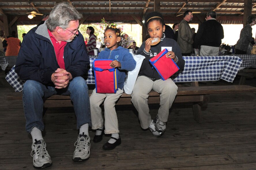 SHAW AIR FORCE BASE, S.C. -- Lynn Nauenburg, 20th Civil Engineer Squadron, talks to Gabriella Ladson, age 3, and Jasmine Ladson, age 9, daughters of Capt. Johnathan Ladson, U.S. Army Central Command operations, about Shaw Air Force Base, March 27. (U.S. Air Force Photo/Senior Aiman David Minor)