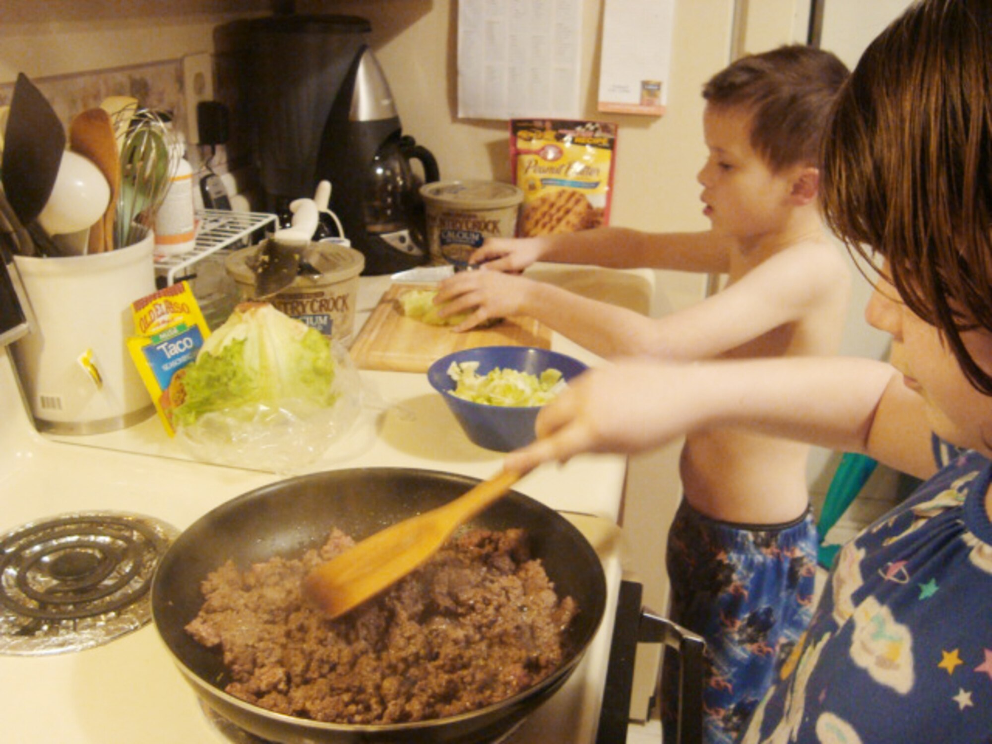 Kristina Urban, 10, cooks the beef while her brother, Paul, 6, shreds lettuce for dinner, March 17, 2010, at at Joint Base Langley-Eustis, Va. Once a week, Kristina and Paul are allowed to prepare a meal for "family cook night" under their parents' supervision. Families learn to make nutritious food choices with FitFamily. Kristina and Paul are the children of Carol and Tech. Sgt. Lou Urban. Sergeant Urban is currently deployed from the 1st Equipment Maintenance Squadron. (U.S. Air Force photo)
