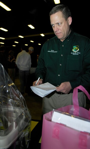 MINOT, N.D. -- Chief Master Sgt. Martin Smith, 5th Bomb Wing command chief master sergeant, places a bid on an item during the silent auction at the 24th Annual Prairie Warrior Association Auction March 27. The auction allows military members and Minot area locals to come together and support the Team Minot family. (U.S. Air Force photo by Senior Airman Benjamin Stratton)