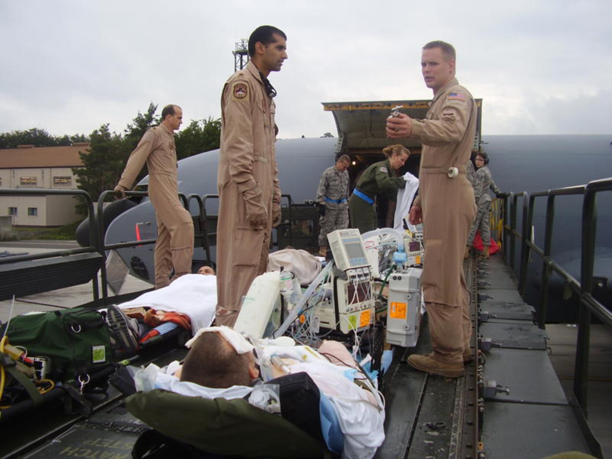 BAGRAM, Iraq - Tech. Sgt. Corey Hellmann, a Reservist from the 920th Rescue Wing's medical squadron at Patrick Air Force Base, Fla. discusses the best way to load a critical care patient onboard an awaiting Air Force transport aircraft for medical evacuation. Sergeant Hellmann volunteered to depoly as a part of the critical care air transport (CCAT) team. The CCAT and aeromedical evacuation teams are a group of highly specialized nurses, physicans, medical technicians and respiratory therapists charged with the responsibility of patient care during medical flying missions out of the war zone. (U.S. Air Force photo)