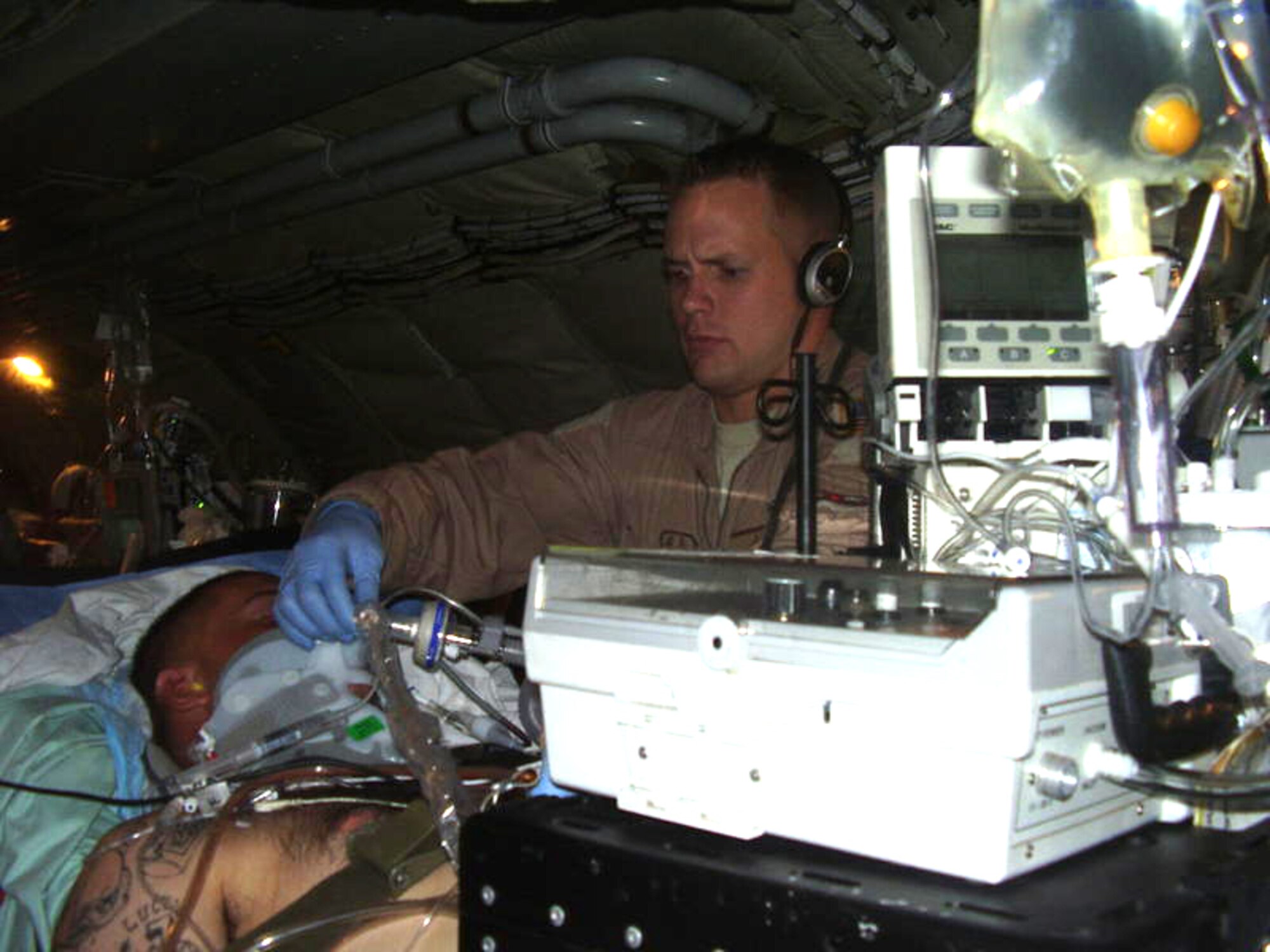 BAGRAM, Iraq - Onboard a military airplane is where Tech. Sgt. Corey Hellmann's medical expertise is most needed. As a reservist from the 920th Rescue Wing's medical squadron, he is deployed from Patrick Air Force Base, Fla. as part of the critical care air transport team (CCAT) where he performs his duties high above the ground. Critical patients are under his care during their evacuation flights out of the war zone. Sergeant Hellmann has volunteered twice for the war effort over the last couple of years and has helped hundreds of wounded Soldiers and Airmen. (U.S. Air Force photo)