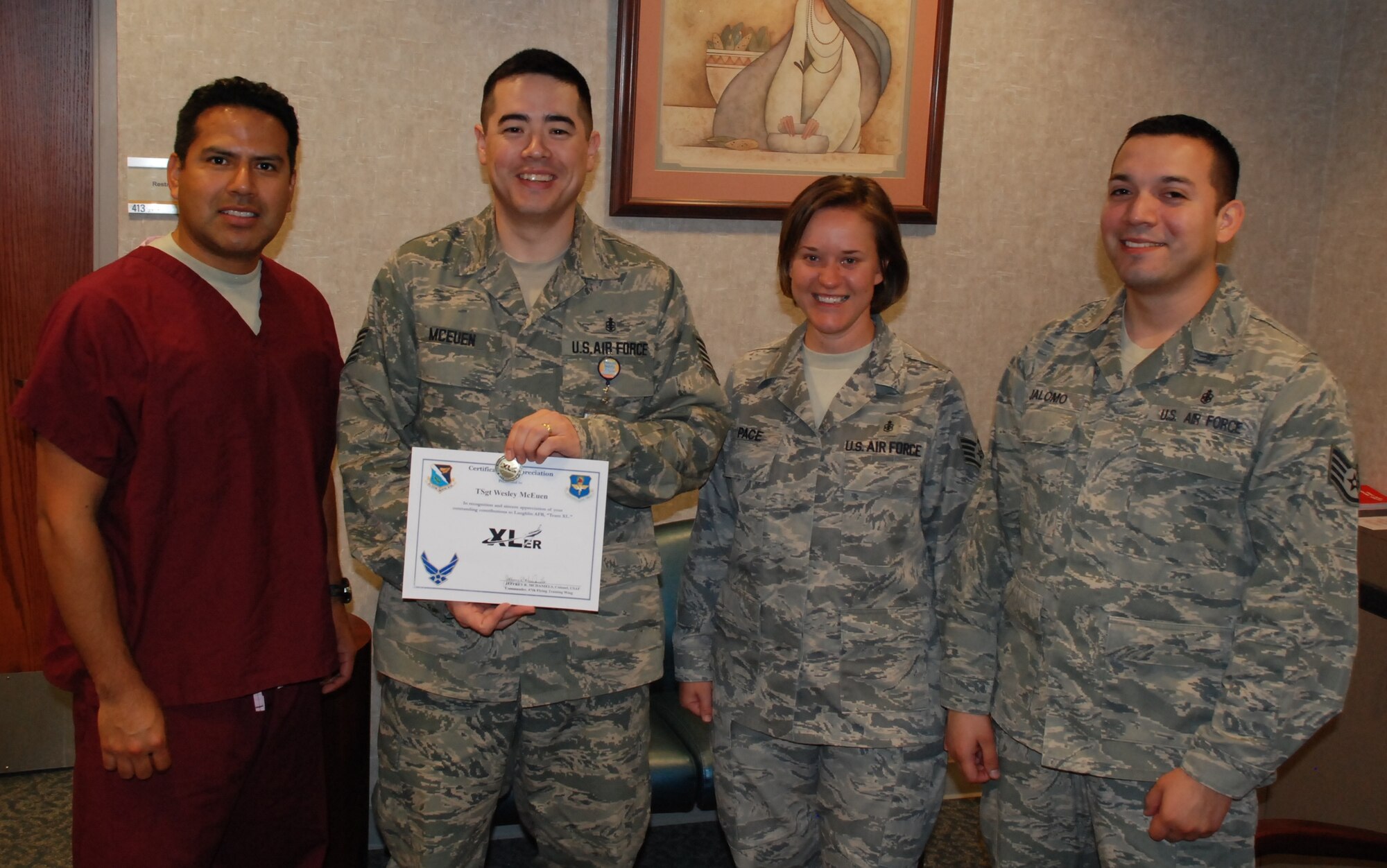 LAUGHLIN AIR FORCE BASE, Texas – Tech. Sgt. Wesley McEuen, 47th Medical Operations Squadron, poses with fellow members of his squadron after being presented the XLer of the Week award by Col. Jeffrey McDaniels, 47th Flying Training Wing commander, March 23. (U.S. Air Force photo by Airman 1st Class Blake Mize)