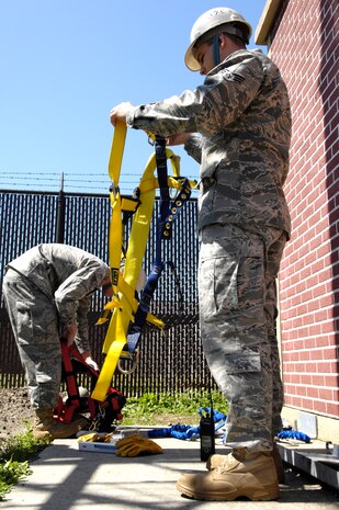 U.S. Air Force Airman 1st Class Amos Hommel, left, and Senior Airman Riley Cusson gear up to climb the radio tower on Joint Base Charleston, S.C., March 23, 2010. Airman Cusson climbed to the top of the 110-foot tower while Airman Hommel climbed halfway. Both Airmen climbed to maintain their climbing certification, which requires a quarterly trip up the tower. Airman Hommel and Airman Cusson are both radio frequency transmissions systems specialists with the 628th Communications Squadron. (U.S. Air Force Photo/Airman 1st Class Lauren Main)