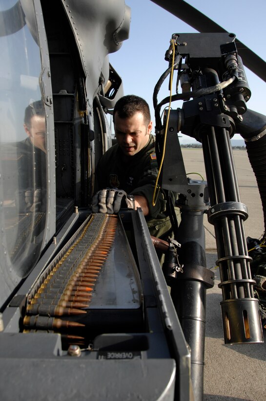 Tech. Sgt. Jimmy Ford, an HH-60G Pave Hawk aerial gunner from the 129th Rescue Squadron, conducts a pre-flight inspection on a GAU-2C Mini-gun at Moffett Federal Airfield, Calif., March 24, 2010. (Air National Guard photo by Tech. Sgt. Ray Aquino)