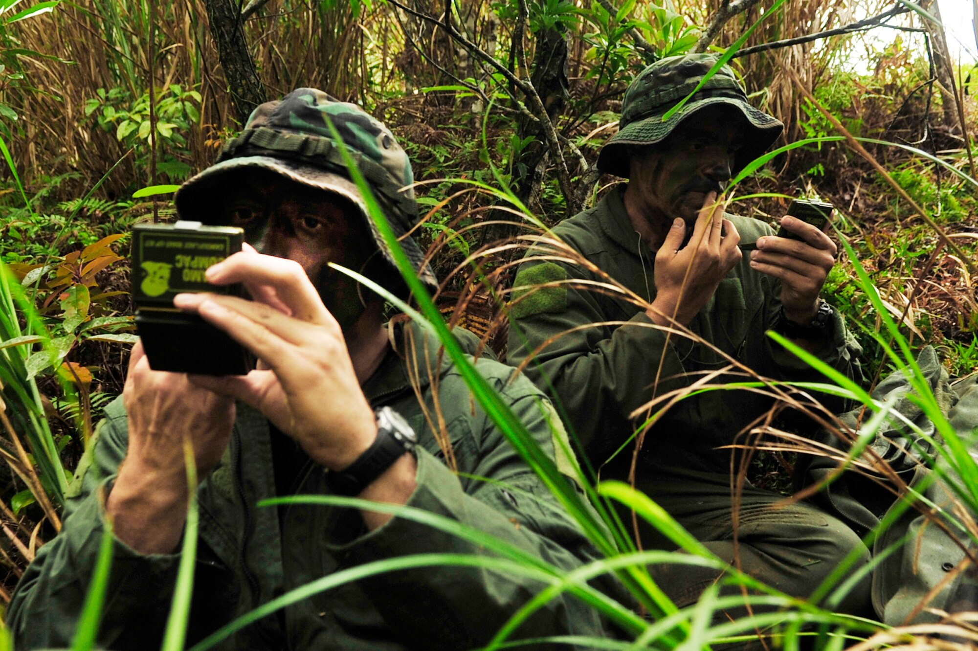 Capt. Aaron Wallace (left) and 1st Lt. Joseph Bisson, both pilots from the 909th Air Refueling Squadron, apply camouflage during an evasion scenario after a simulated KC-135 crash at Kadena Air Base, Japan, March 25, 2010. Members of the 909th ARS trained in proper survival and evasion procedures as part of a local operational readiness exercise. (U.S. Air Force photo/Senior Airman Amanda N. Grabiec)