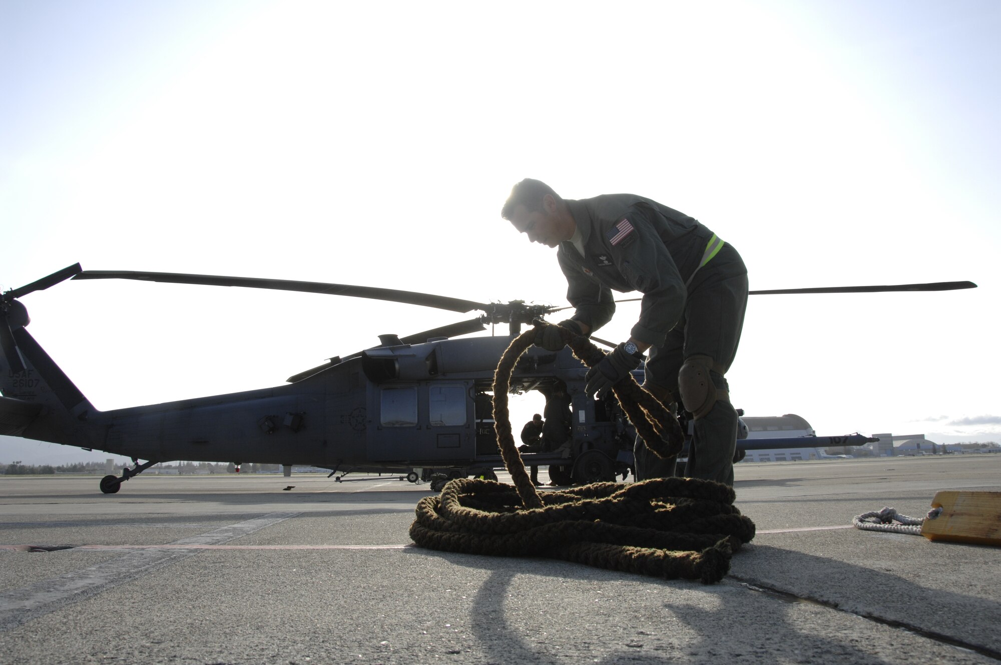 Chief Master Sgt. Richard Nowaski, an HH-60G Pave Hawk flight engineer from the 129th Rescue Squadron, prepares a rope used by pararescuemen for helicopter fast-roping at Moffett Federal Airfield, Calif., March 24, 2010. (Air National Guard photo by Tech. Sgt. Ray Aquino)