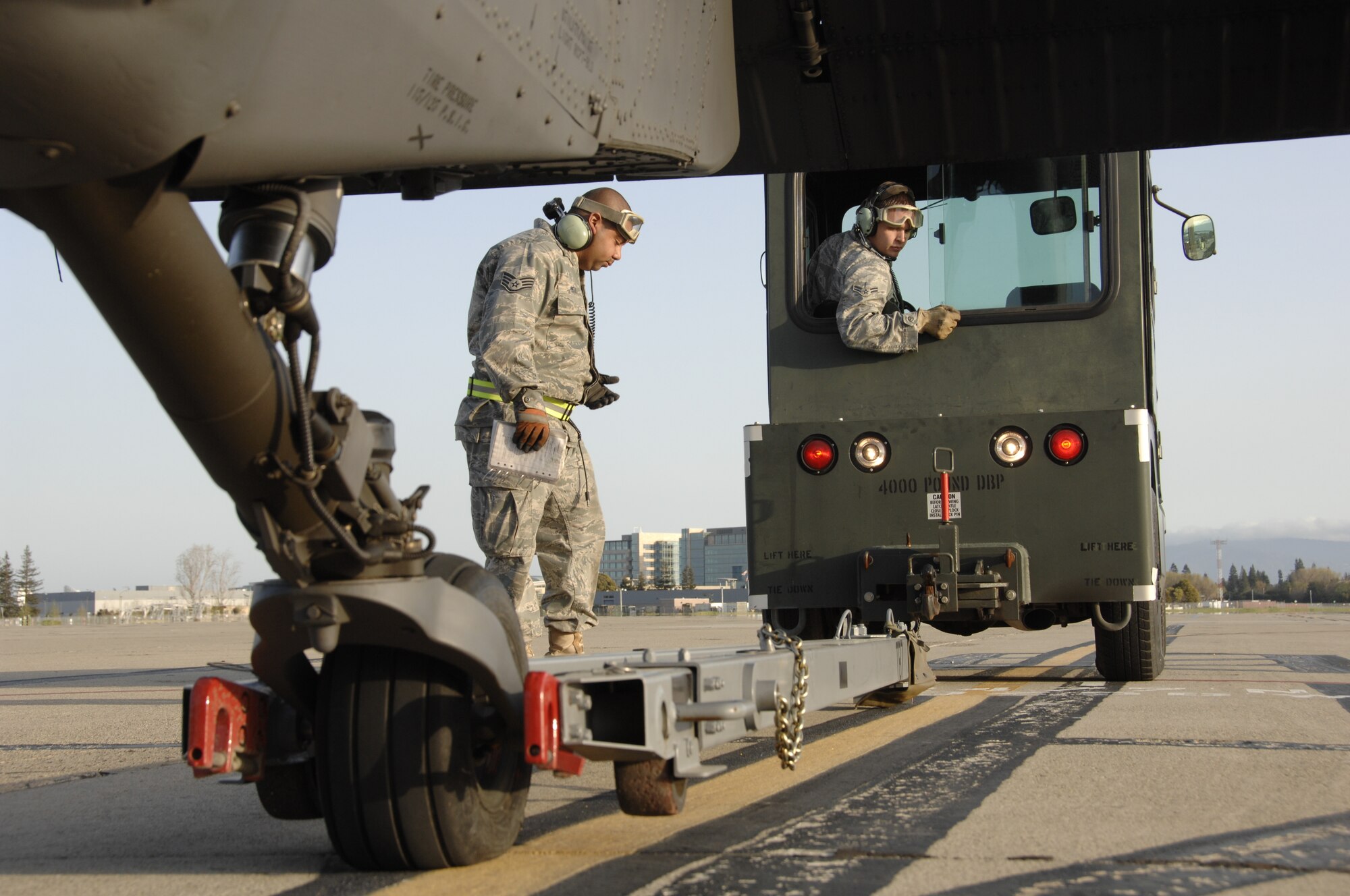 Staff Sgt. David Ortiz and Airman 1st Class Joshua Tidwell, HH-60G Pave Hawk crew chiefs from the 129th Maintenance Squadron, prepare a Pave Hawk for towing at Moffett Federal Airfield, Calif., March 24, 2010. (Air National Guard photo by Tech. Sgt. Ray Aquino)