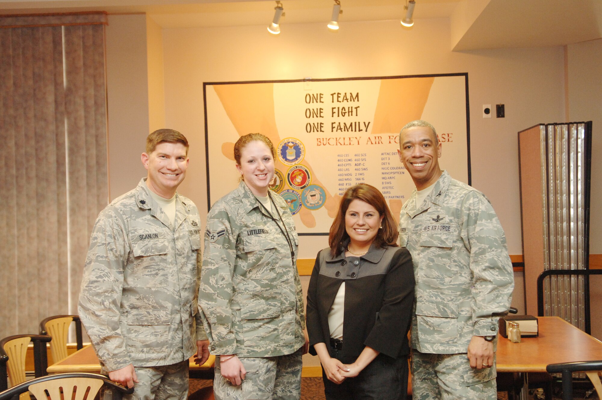 BUCKLEY AIR FORCE BASE, Colo. -- Col. Vincent Jefferson, 460th Mission Support Group commander, and Lt. Col. David Scanlon, 566th Intelligence Squadron commander, pose with Staff Sgt. Marie Jarado and Airman 1st Class Laurice Littlefield, 566th IS, March 26 at Newtch's Den. Sergeant Jarado and Airman Littlefield painted the mural. (U.S. Air Force photo by Tech. Sgt. Shirley Henderson)