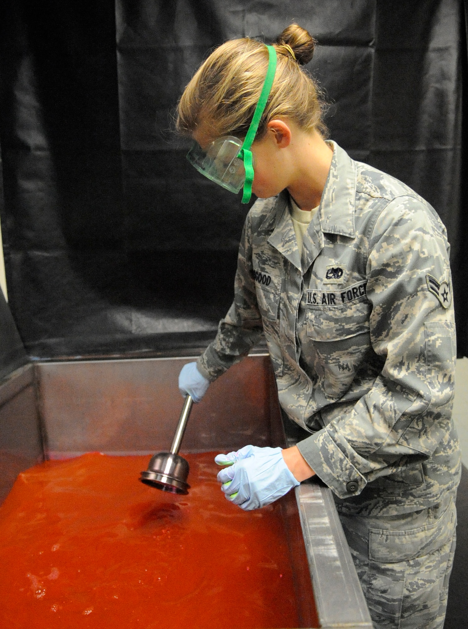 LANGLEY AIR FORCE BASE, Va.-- Airman First Class Danna Osgood, 1st Equipment Maintenance Squadron Non-Destructive Inspection apprentice, dips a F-15C Eagle  bell house hydraulic component into penetration fluid in preparation for inspection March 22. NDI inspects for cracks and flaws on aircraft and their components, aerospace ground equipment, safety equipment and also tests jet engine oil samples, using a variety of methods, like magnetic particle, fluorescent penetrant, eddy current, radiography, optical and ultrasonic equipment. (U.S. Air Force photo/ Senior Airman Dana Hill)