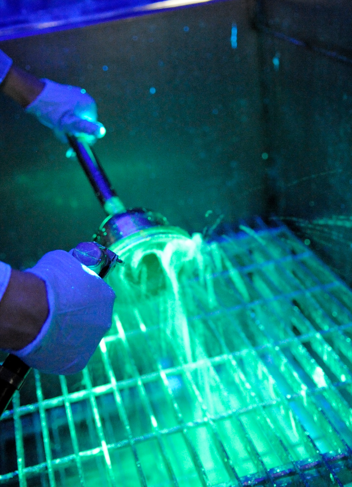 LANGLEY AIR FORCE BASE, Va.-- Airman First Class Danna Osgood, 1st Equipment Maintenance Squadron Non-Destructive Inspection apprentice, rinses a F-15C Eagle bell house hydraulic component in preparation for inspection March 22. NDI inspects for cracks and flaws on aircraft and their components, aerospace ground equipment, safety equipment and also tests jet engine oil samples, using a variety of methods, like magnetic particle, fluorescent penetrant, eddy current, radiography, optical and ultrasonic equipment. (U.S. Air Force photo/ Senior Airman Dana Hill)