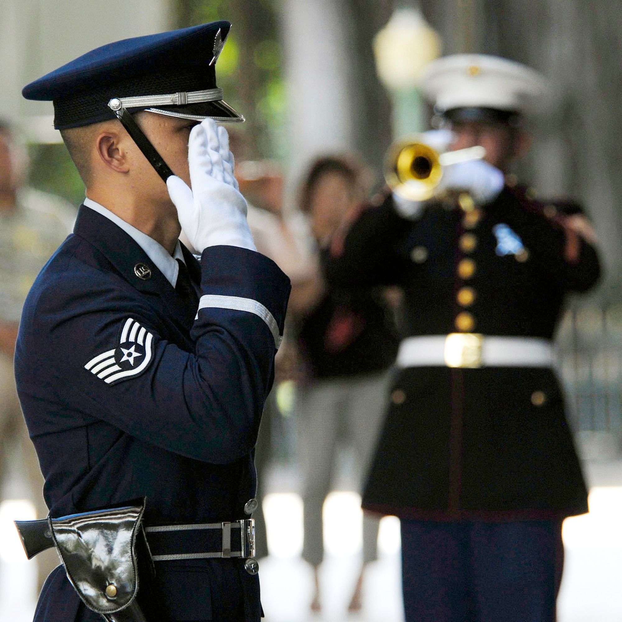 A member of the Joint Base Hickam-Pearl Harbor, Hawaii, honor guard salutes during a rifle volley and the playing of "Taps" by a Marine Corps bandsman to honor 28 fallen servicemembers being presented the Hawaii Medal of Honor posthumously during a special ceremony March 23, 2010, at the State Capitol in Honolulu, Hawaii. The Hawaii Medal of Honor was created in 2005 to recognize the heroism of those members of the U.S. armed forces with links to Hawaii who are killed in action while serving our country as part of Operation Iraqi Freedom and Operation Enduring Freedom in Iraq and Afghanistan. (U.S. Air Force photo/Tech. Sgt. Jerome S. Tayborn)