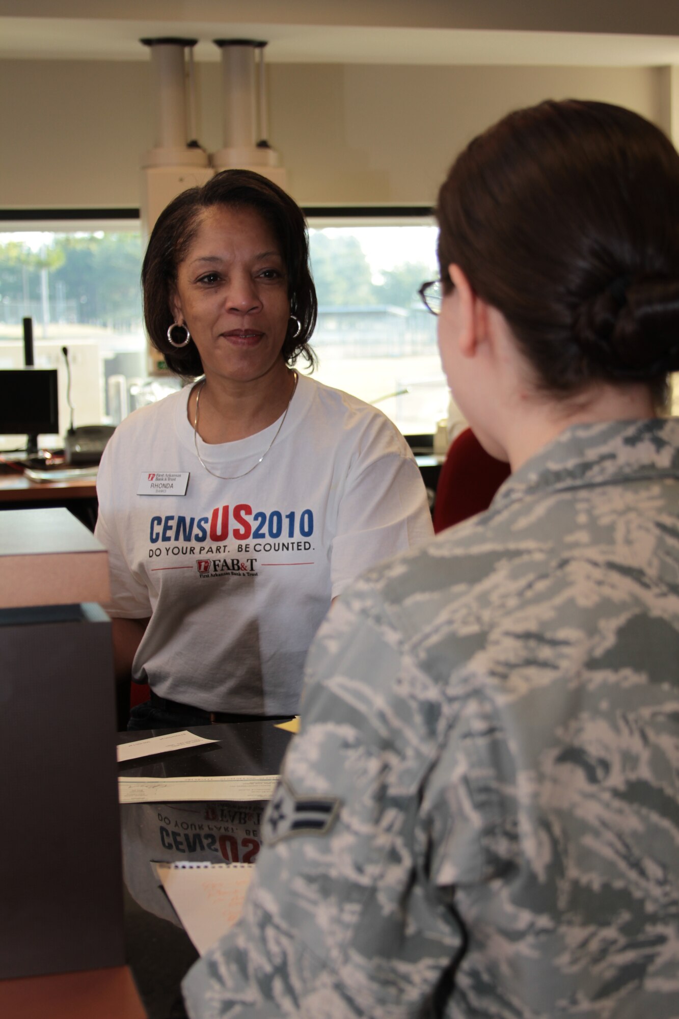 Rhonda Banks, First Arkansas Bank and Trust branch manager and teller supervisor, helps a customer with a deposit March 26 at the bank on base. Bank personnel are wearing Census 2010 T-shirts to remind people to submit their census forms and show their commitment to the success and growth of the communities they serve. (U.S. Army photo Spc. Jared Sollars)
