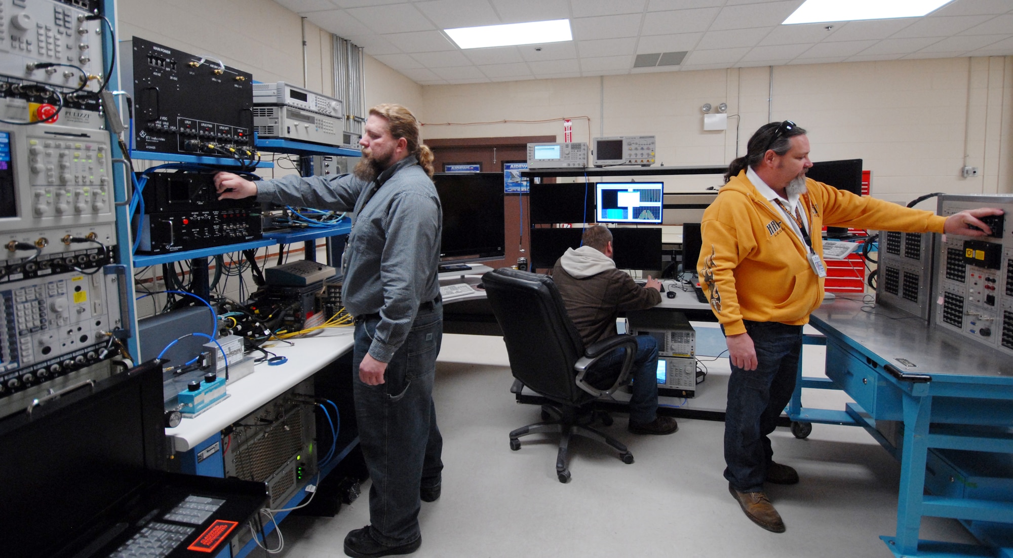 Rob Stoner, Kevin McNeal and Bob Korn, 68th Electronic Warfare Squadron contractors, prepare the Advanced Integrated Defense Electronic Warfare System test lab for a test run.  Members of the Advanced Systems Flight of the 68th EWS, work closely with their foreign customers to facilitate future requirements so their mission data can be tailored to the ever-changing threat environment and define customer's necessities to build future products.  (U.S. Air Force photo/Samuel King Jr.) 