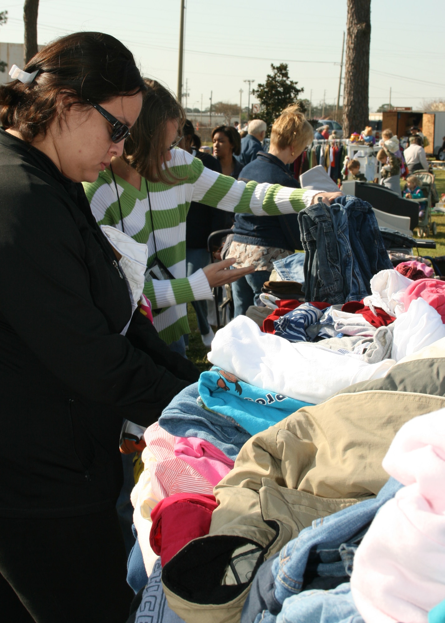 EGLIN AIR FORCE BASE, Fla. - Women look over clothes laid across many tables to find a bargain at the base's annual yard sale March 27. Hundreds of shoppers and around 60 vendors came to  to look for good deals. Families brought old items along with crafts to sell at the event. (U.S. Air Force photo/ 2d Lt. Andrew Caulk)