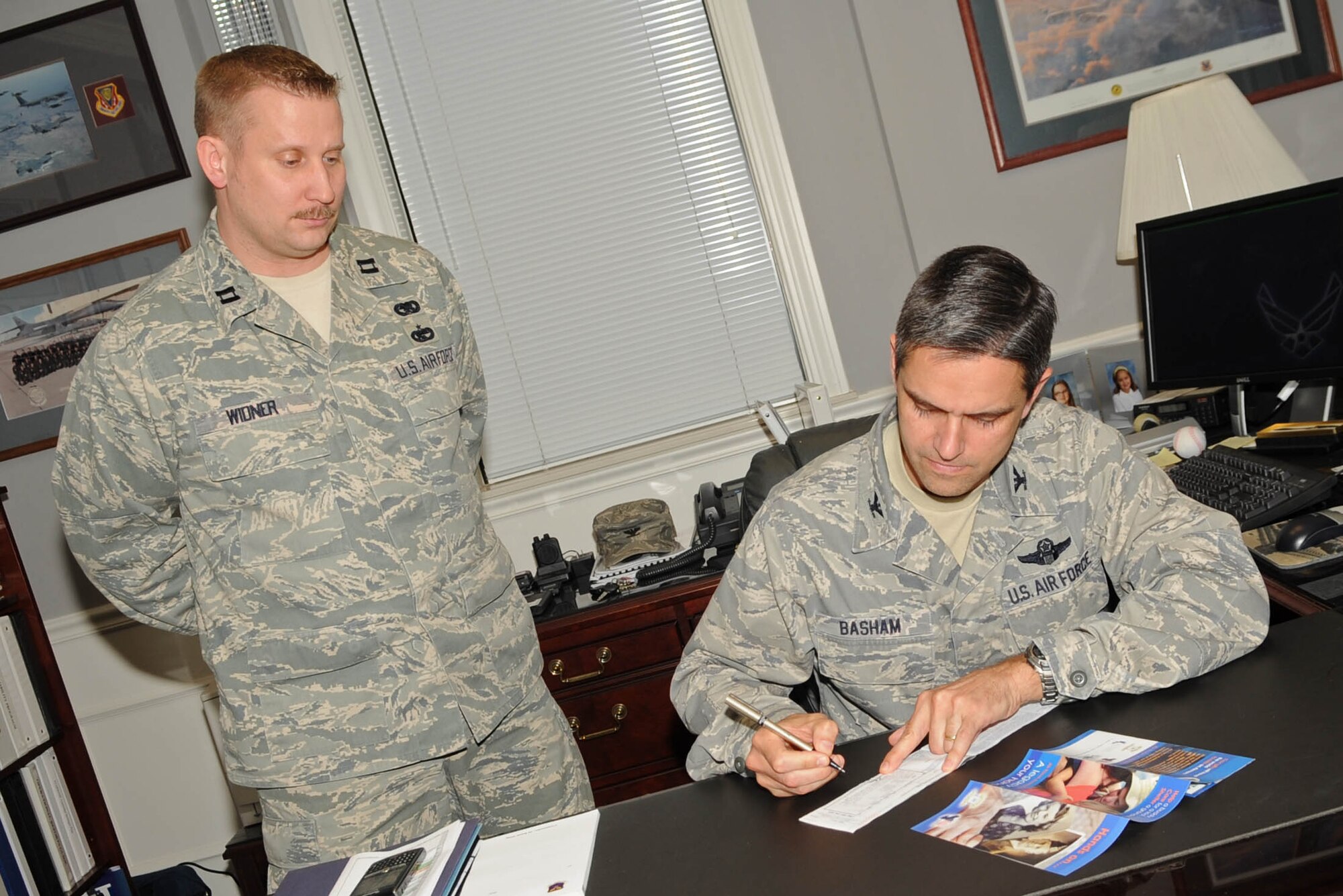 BARKSDALE AIR FORCE BASE, La. – Col. Steven Basham, 2d Bomb Wing commander, fills out an Air Force Assistance Fund donation slip March 29 as Capt. Dennis Widner, 2d Logistics Readiness Squadron, stands by. Barksdale will be accepting donations now through May 7. This year’s goal is 100 percent contact with all Barksdale Airmen and raising $100,221. (U.S. Air Force photo by Senior Airman Alexandra Longfellow) (RELEASED)