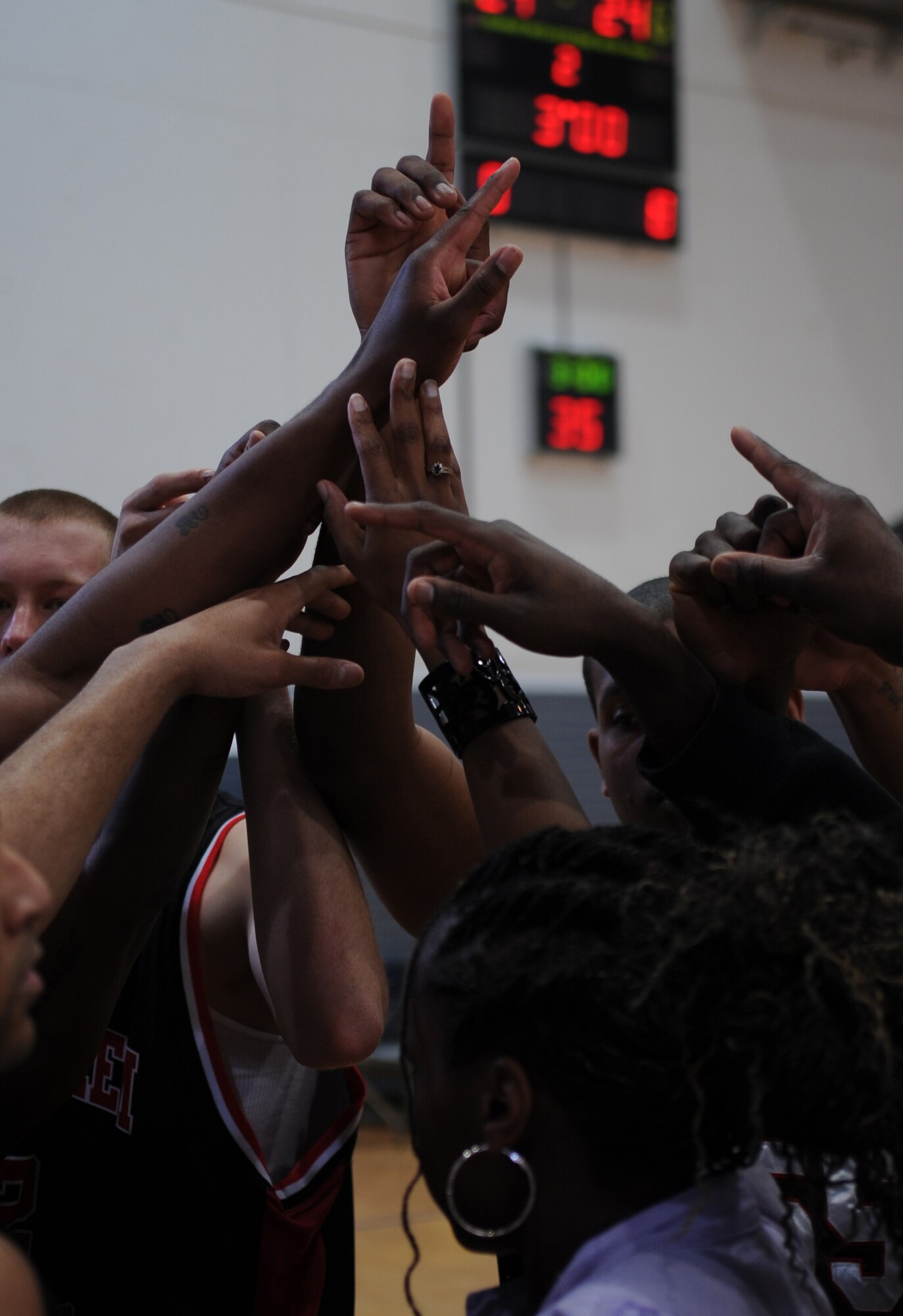 Spangdahlem Sabers team members and coach U.S. Air Force Staff. Sgt. Myisha Hudson, put their hands together after a sideline huddle during a U.S. Forces Europe basketball game, Ramstein Air Base, Germany, March 24, 2010. The 86th Services Squadron hosted the U.S. Armed Forces Europe Men's and Women's basketball championship series, a tournament consisting of U.S. servicemembers, dependents and retirees from around the European Theater. (U.S. Air Force photo by Airman 1st Class Caleb Pierce)