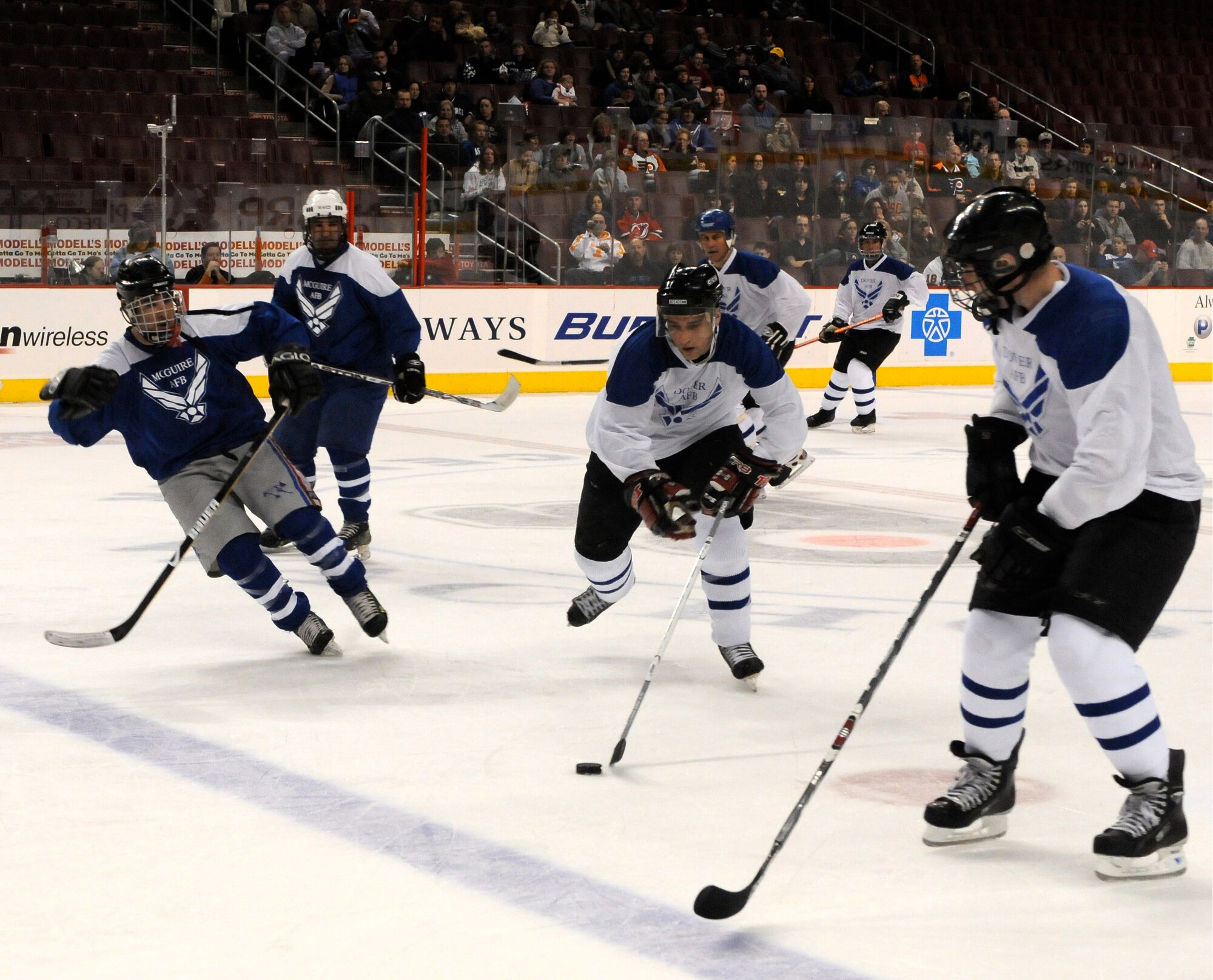 Dover All-Stars players slip past the McGuire All-Star defense with the puck during an annual fundraiser hockey match in Philadelphia at the Wachovia Center Mar. 28. The game, held prior to the Philadelphia Flyers match, ended with Dover losing to McGuire, 6-8. Dover's team was comprised of regular Air Force members, reservists and civilians from the 512th and 436th Airlift Wings. (U.S. Air Force photo/Staff Sgt. Steve Lewis) 