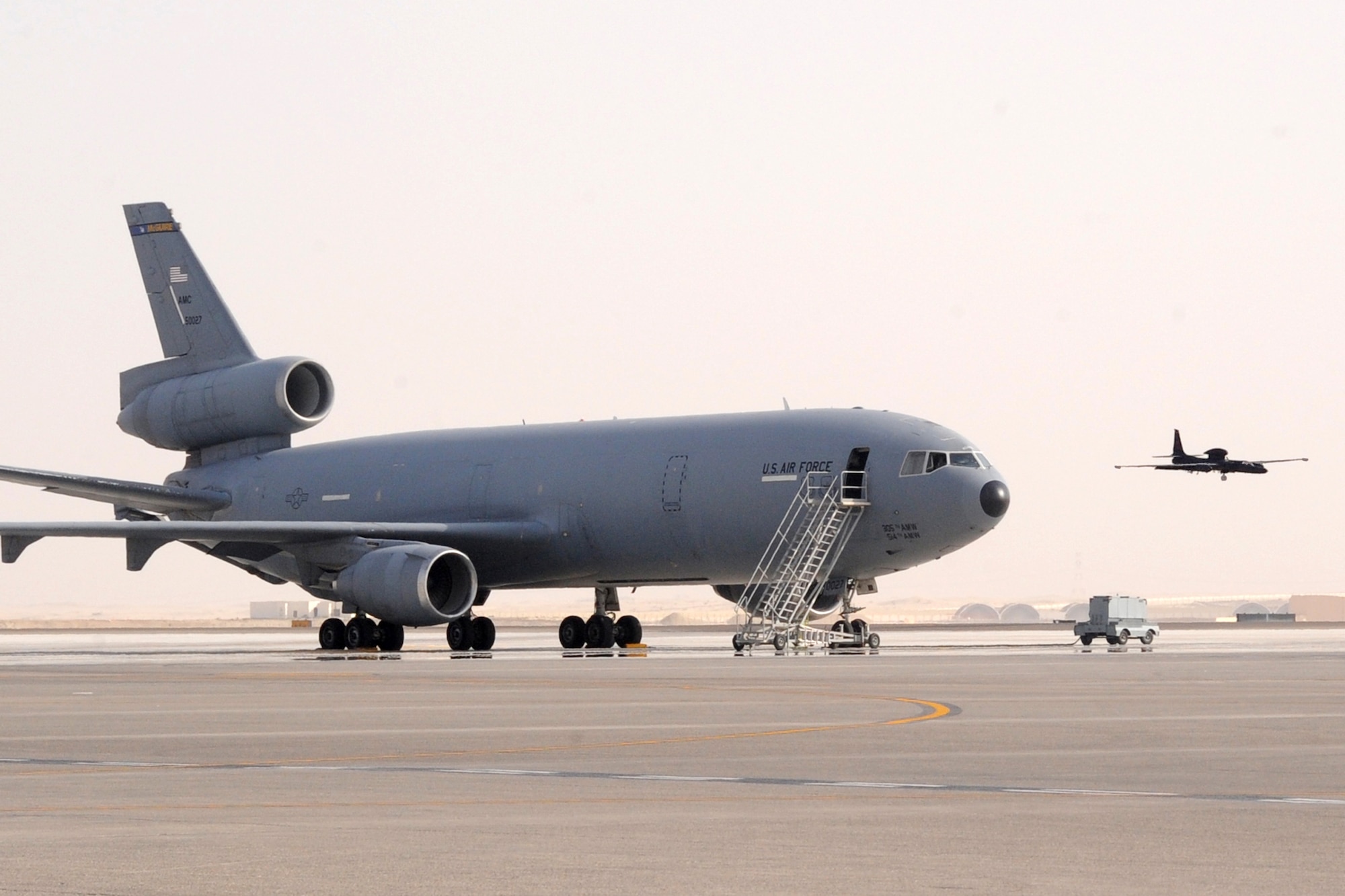 A U-2 Dragon Lady lands while passing over a KC-10 Extender at the 380th Air Expeditionary Wing at an undisclosed location in Southwest Asia on March 26, 2010. the 380th Air Expeditionary Wing, supports Operations Iraqi Freedom and Enduring Freedom and the Combined Joint Task Force-Horn of Africa. The 380th AEW is comprised of four groups and 12 squadrons and the wing's deployed mission includes air refueling, surveillance and reconnaissance in support of overseas contingency operations in Southwest Asia. (U.S. Air Force photo/Senior Airman Jenifer H. Calhoun/Released)
