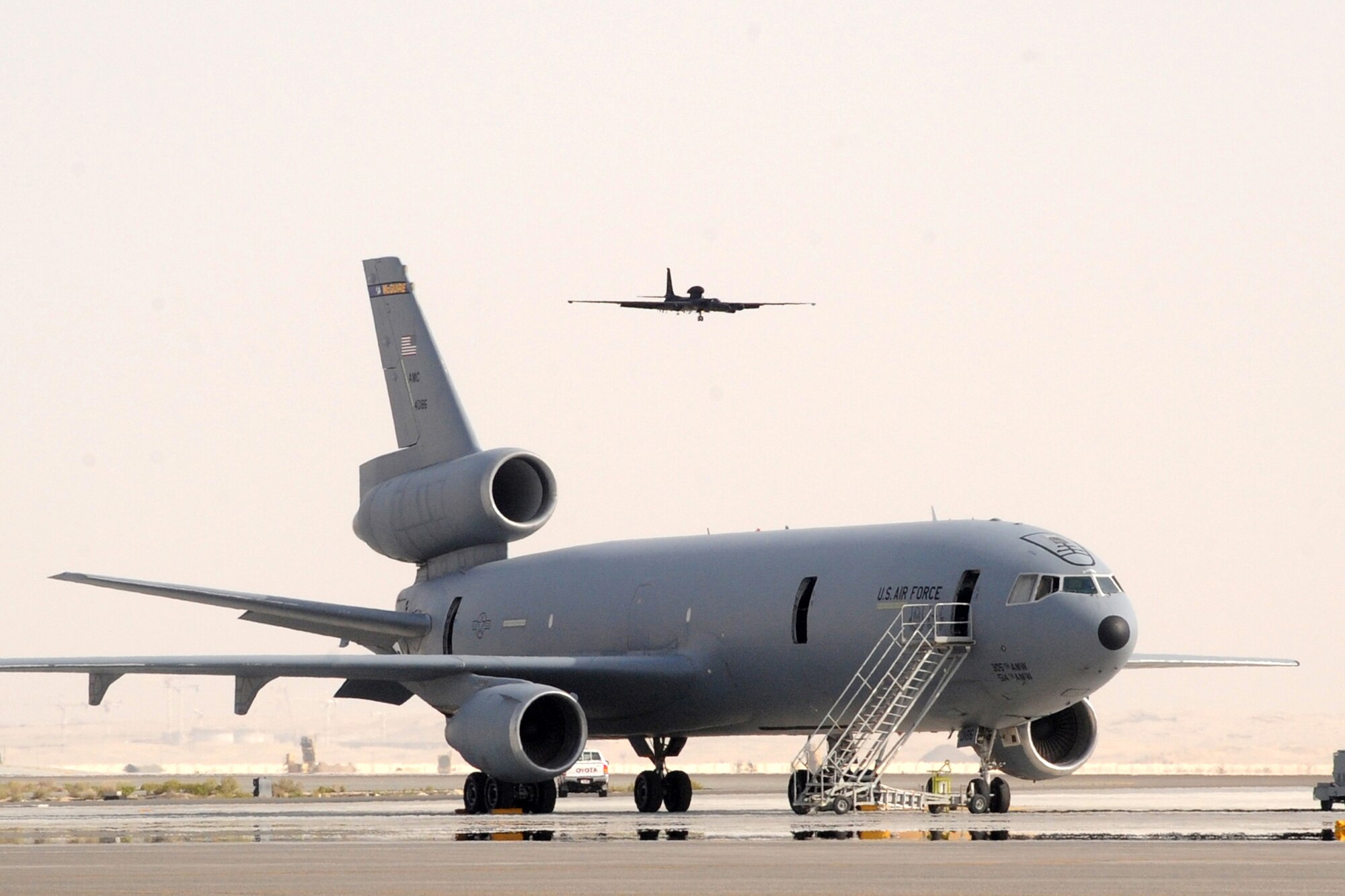 A U-2 Dragon Lady lands while passing over a KC-10 Extender at the 380th Air Expeditionary Wing at an undisclosed location in Southwest Asia on March 26, 2010. the 380th Air Expeditionary Wing, supports Operations Iraqi Freedom and Enduring Freedom and the Combined Joint Task Force-Horn of Africa. The 380th AEW is comprised of four groups and 12 squadrons and the wing's deployed mission includes air refueling, surveillance and reconnaissance in support of overseas contingency operations in Southwest Asia. (U.S. Air Force photo/Senior Airman Jenifer H. Calhoun/Released)
