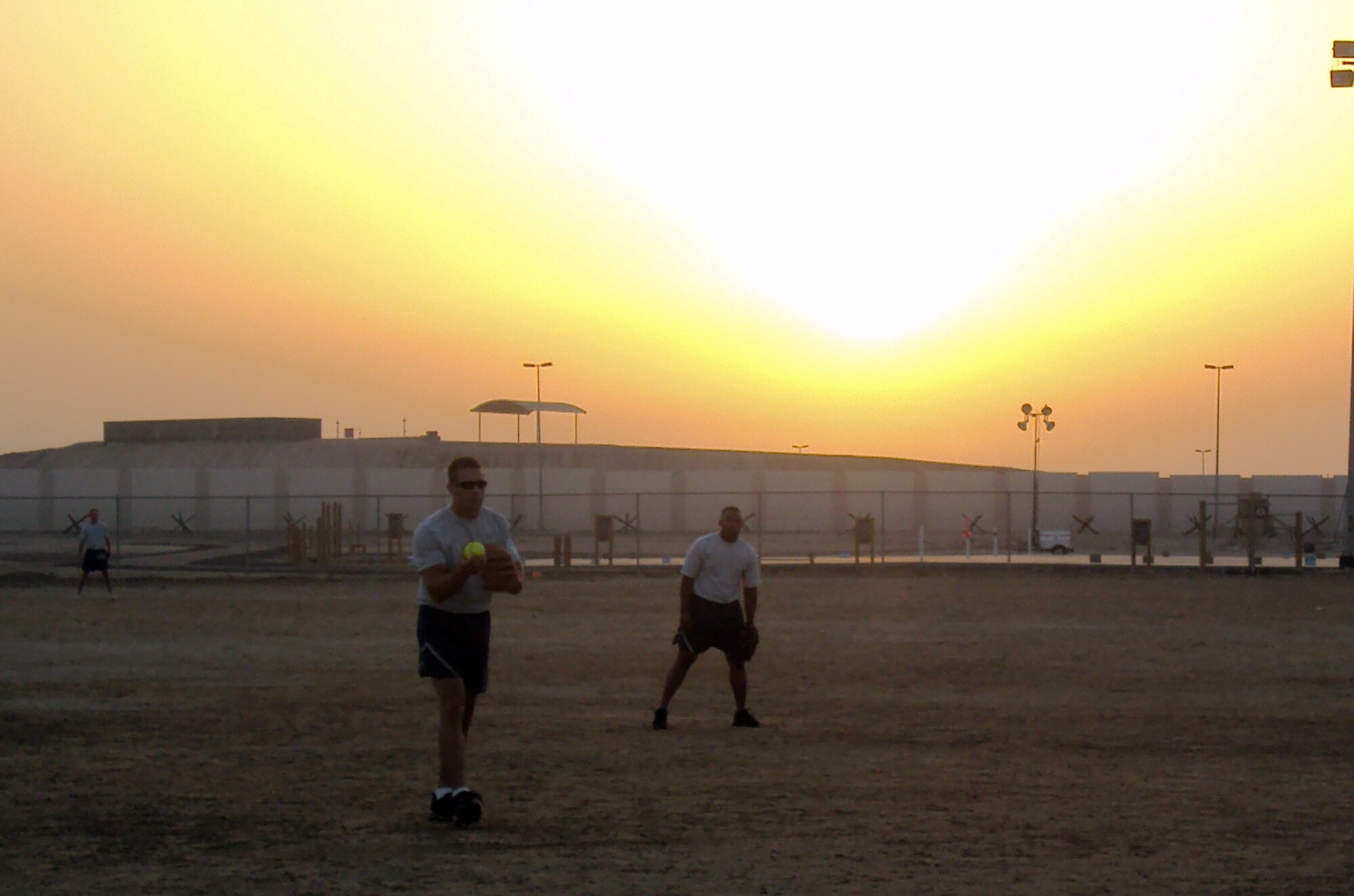 Airmen from the 380th Air Expeditionary Wing play a game of softball on a sand field at a non-disclosed base in Southwest Asia on March 25, 2010.  (U.S. Air Force Photo/Master Sgt. Scott T. Sturkol/Released)