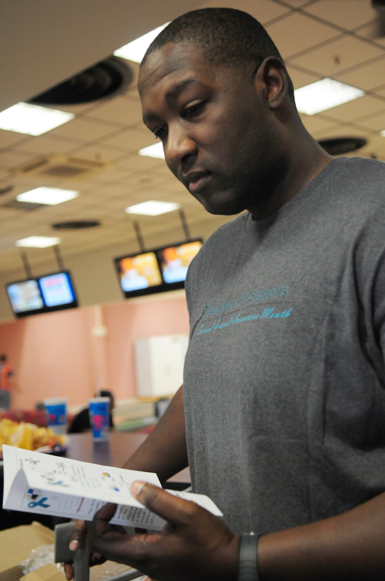 SPANGDAHLEM AIR BASE, Germany -- Tech. Sgt. Terrence Baptiste, 52nd Force Support Squadron Manpower, reviews scheduled events for Sexual Assault Awareness Month during the bowl-a-thon at Eifel Lanes Bowling Center March 25.  This year’s theme “Hurts One…Affects All” is being showcased through a variety of events March 15 - April 16 to raise awareness to stress negative effects of sexual assault.  (U.S. Air Force photo/Staff Sgt. Heather M. Norris)