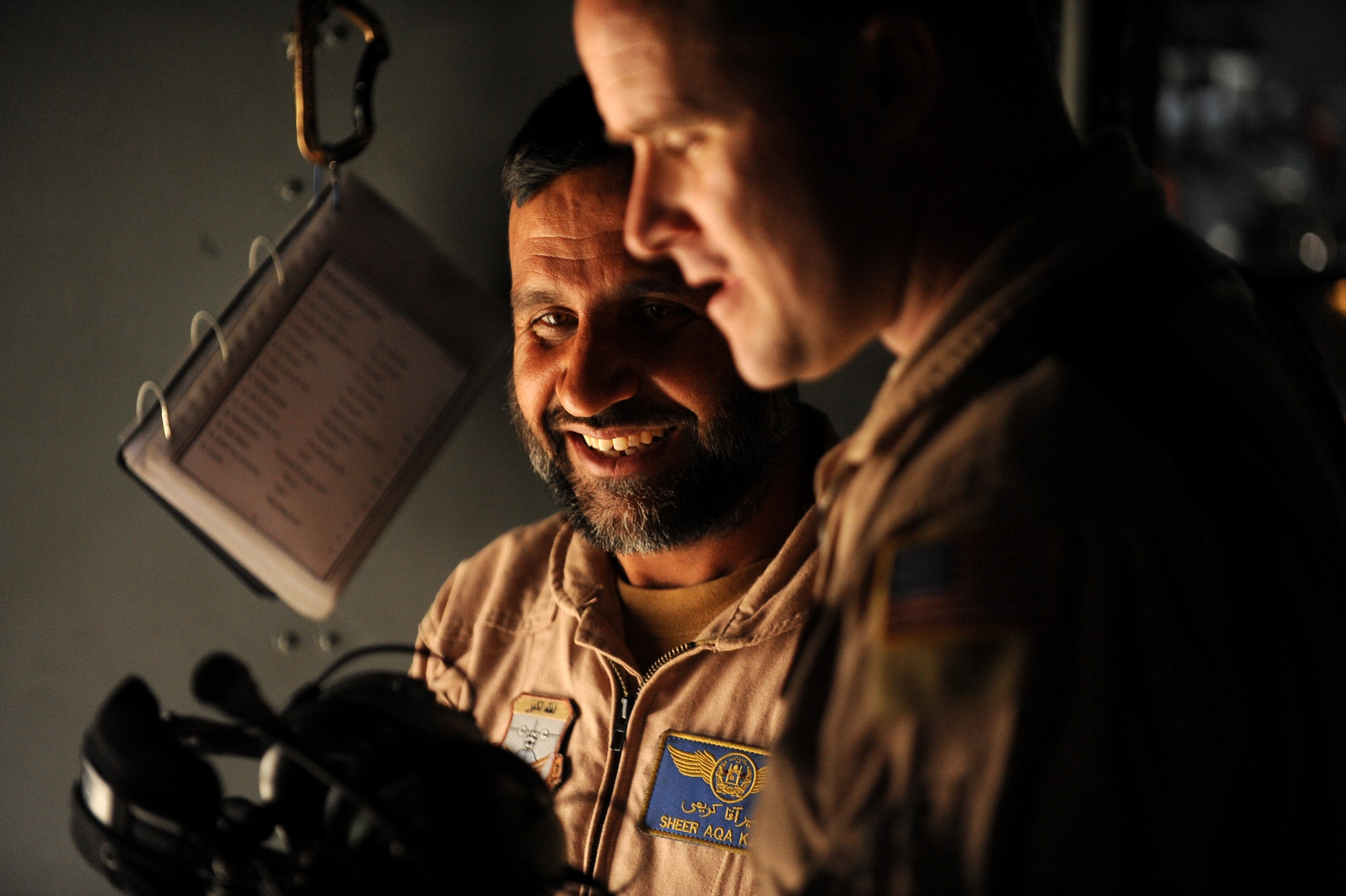 Afghanistan National Army Air Corps Master Sgt. Sheer Aqa Karimi, a C-27A Spartan loadmaster, and Master Sgt. Chris Ringland, 438th Air Expeditionary Advisory Group standards and evaluation loadmaster, socialize prior to take-off for a check ride for Sergeant Karimi, March 28, 2010, at Kabul International Airport, Afghanistan. "Sheer Aqa is one of the brightest and energetic students we have," said Sergeant Ringland, who is deployed from the 6th SOSS at Hurlburt Field. "He did a great job today and I would be proud to fly with him anywhere in the world." Admitting he was a bit nervous, Sergeant Karimi, was pleased at the success of the mission and is happy to be his country's first qualified C-27 loadmaster. (U.S. Air Force/ Staff Sgt. Manuel J. Martinez/released) 
