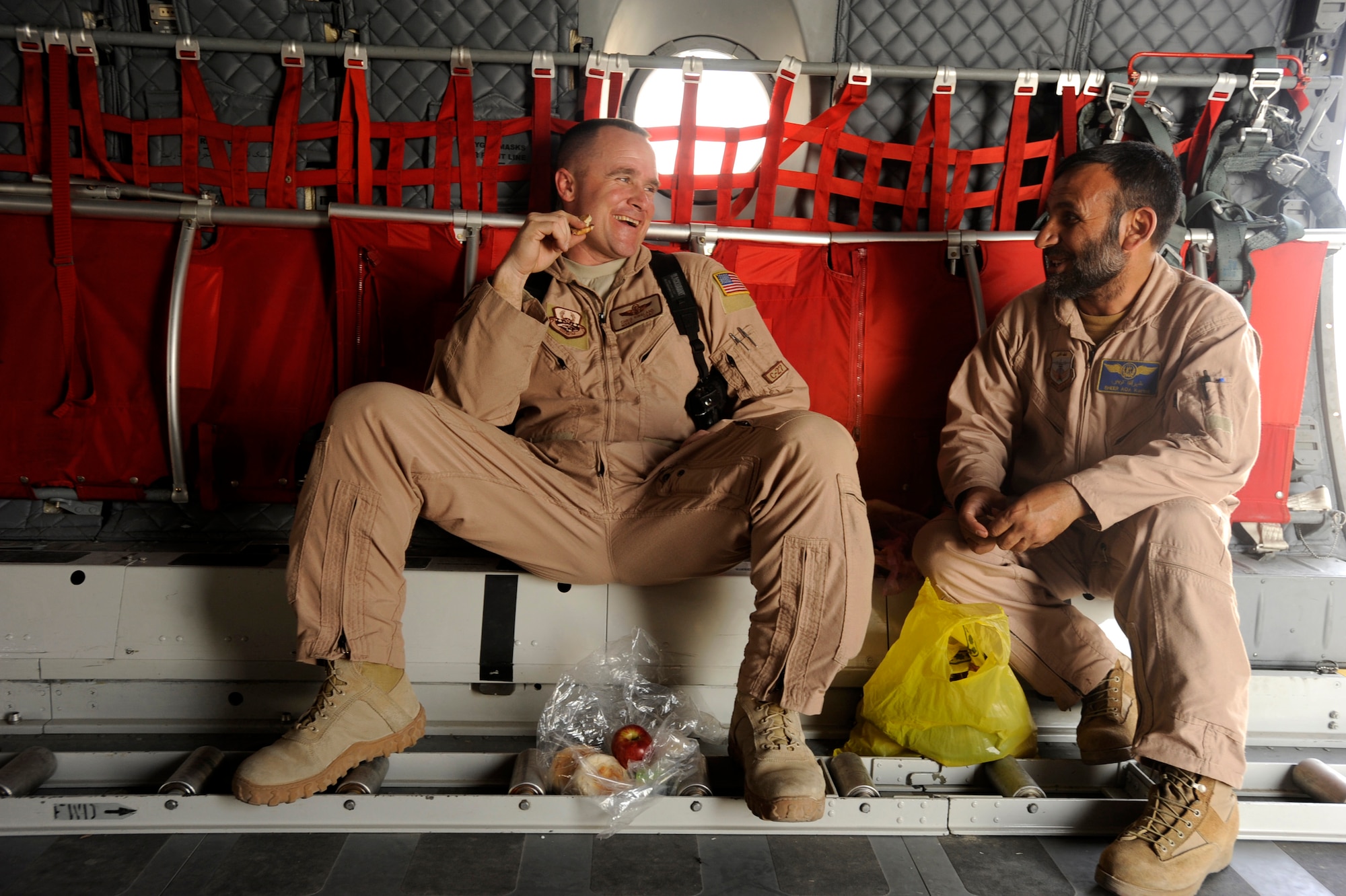 Master Sgt. Chris Ringland, 438th Air Expeditionary Advisory Group standards and evaluation loadmaster, and Afghanistan National Army Air Corps Master Sgt. Sheer Aqa Karimi, a C-27A Spartan Loadmaster, socialize during a chow break, March 28, 2010, at Camp Bastion, Afghanistan. "The best thing about getting the Afghans qualified is having them available to help train the next group of students," said Sergeant Ringland, a native of Navarre, Fla. "They will be invaluable to the progress of their program,  I am very proud of my Afghan brother and look forward to what?s next." (U.S. Air Force/ Staff Sgt. Manuel J. Martinez/released) 
