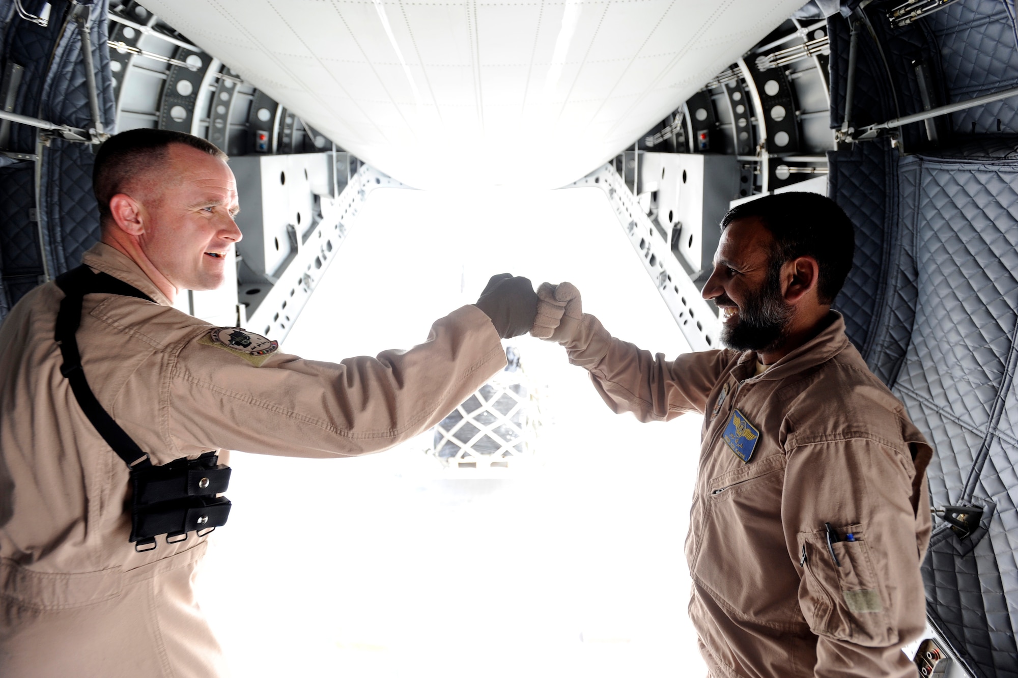 Master Sgt. Chris Ringland, 438th Air Expeditionary Advisory Group standards and evaluation loadmaster, and Afghanistan National Army Air Corps Master Sgt. Sheer Aqa Karimi, a C-27A Spartan Loadmaster, congratulate each other after successfully unloading the missions cargo, March 28, 2010, at Camp Bastion, Afghanistan. During an almost two-hour International Security Assistance Force operational mission to deliver more than 2,400 pounds of weapons and supplies for Afghanistan Nation Police at Camp Bastion.  ANAAC C-27 loadmaster, Afghan Master Sgt. Sheer Aqa Karimi, was evaluated by Master Sgt. Chris Ringland, 438th Air Expeditionary Advisory Group standards and evaluation loadmaster. (U.S. Air Force/ Staff Sgt. Manuel J. Martinez/released) 
