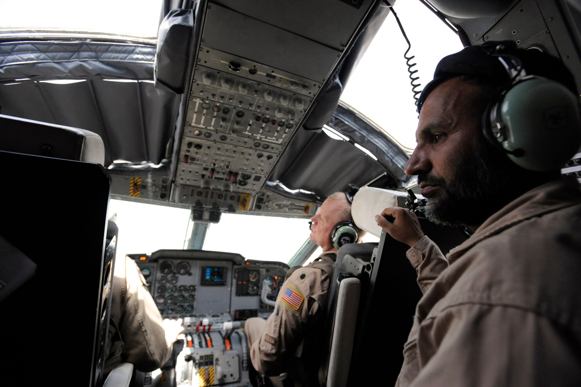 Afghanistan National Army Air Corps Master Sgt. Sheer Aqa Karimi, a C-27A Spartan loadmaster, listens to the pilots while performing loadmaster duties for  Brigadier General Michael Boera left, 438th Air Expeditionary Wing and Combined Air Power Transition Force commander, and Lt. Col. Chris Kampsen, the director of operations for the 538th Air Expeditionary Advisory Squadron and a C-27 instructor, prior to taking off for an operational mission and C-27 loadmaster check ride,  March 28, 2010, at Camp Bastion, Afghanistan. During the flight a loadmaster assists the pilot by running checklists and checking engine and hydraulic systems to ensure passengers and cargo arrive at their destination safely. During the check ride Sergeant Karimi was evaluated on how he executed all of the loadmaster duties. (U.S. Air Force/ Staff Sgt. Manuel J. Martinez/released) 