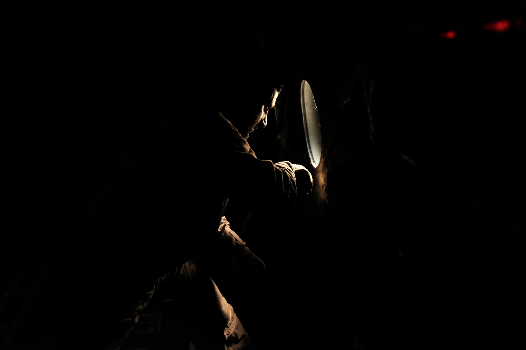 Afghanistan National Army Air Corps Master Sgt. Sheer Aqa Karimi, a C-27J Spartan loadmaster, opens the paratroop door of a C-27 during his check ride aboard a C-27, March 28, 2010, at Kabul International Airport, Afghanistan. (U.S. Air Force/ Staff Sgt. Manuel J. Martinez/released) 