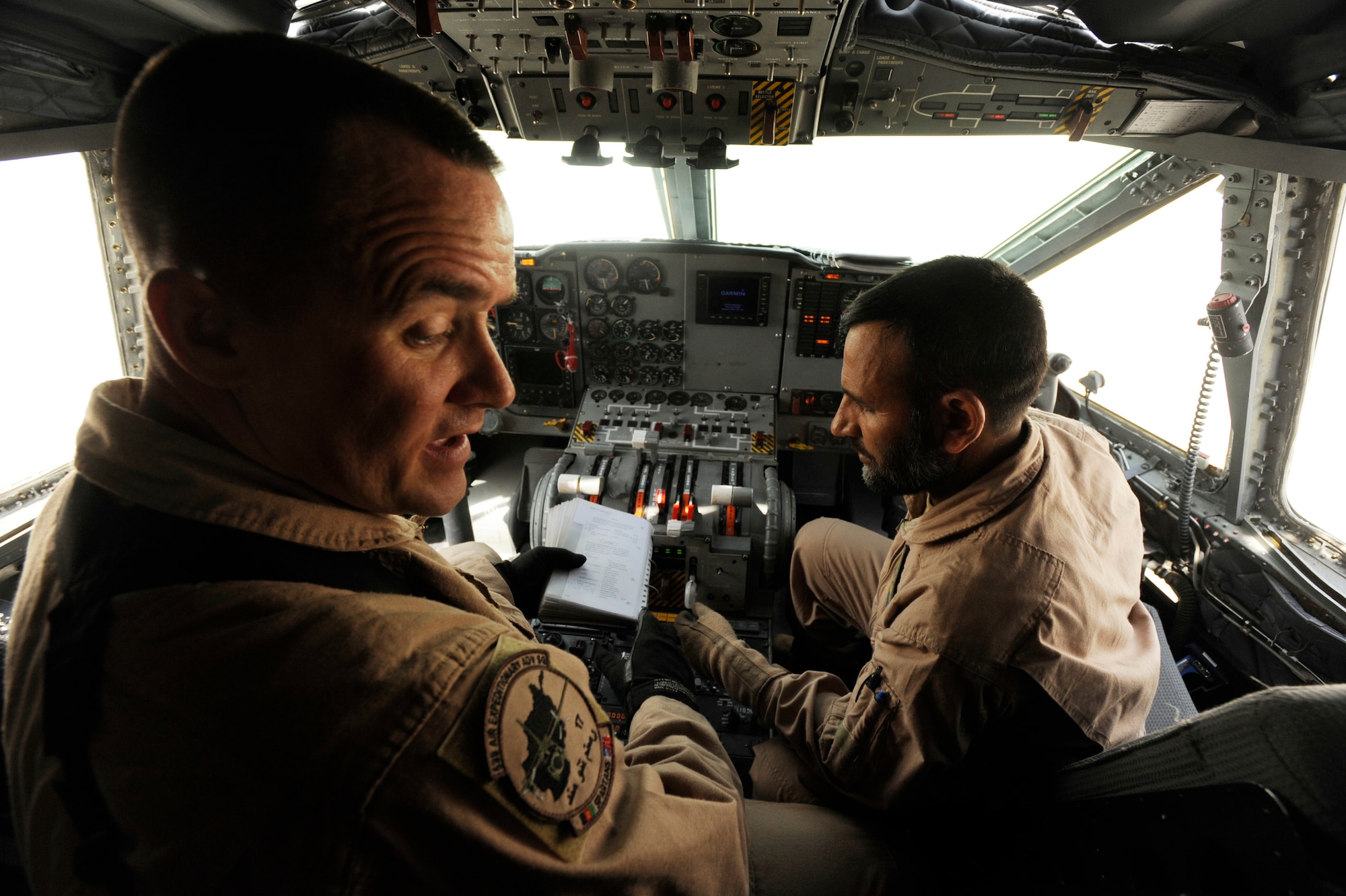 Master Sgt. Chris Ringland, 438th Air Expeditionary Advisory Group standards and evaluation loadmaster, evaluates Afghanistan National Army Air Corps Master Sgt. Sheer Aqa Karimi, a C-27A Spartan loadmaster, as he performs instrument checks during a check ride for Sergeant Karimi aboard a C-27, March 28, 2010, at Kabul International Airport, Afghanistan. (U.S. Air Force/ Staff Sgt. Manuel J. Martinez/released) 