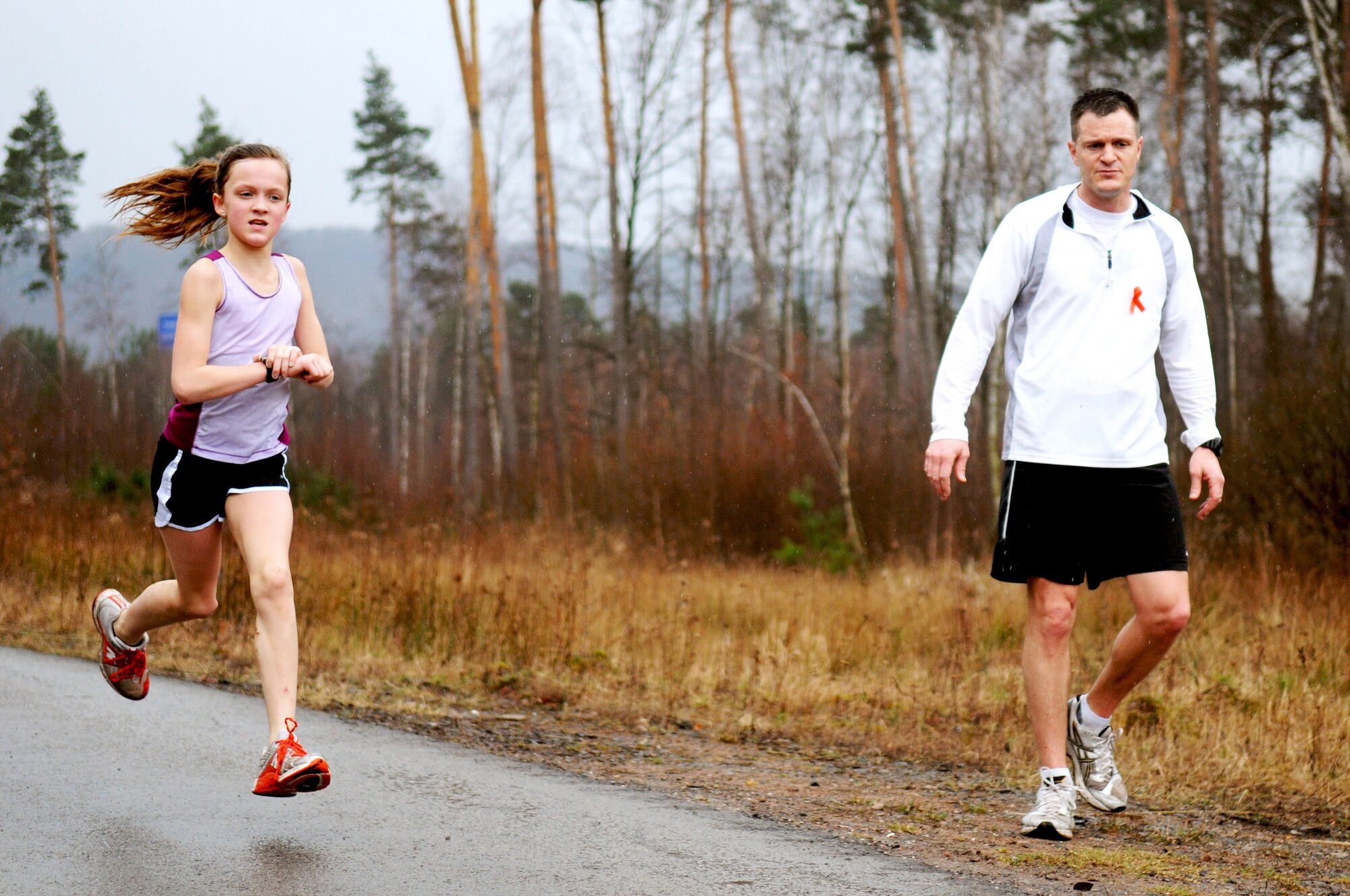 Lt. Col Seth Frank, 86th Security Forces Squadron commander, cheers on his daughter Kylie Frank at the home stretch of the 2nd Annual 5K LOVESWEET memorial run on Ramstein Air Base, Germany, March 20, 2010. The run was in honor of Tech. Sgt. Jessica Sweet, 435th Communication Squadron supply Airman, who lost a hard fought battle to Acute Myeloid Leukemia last year.