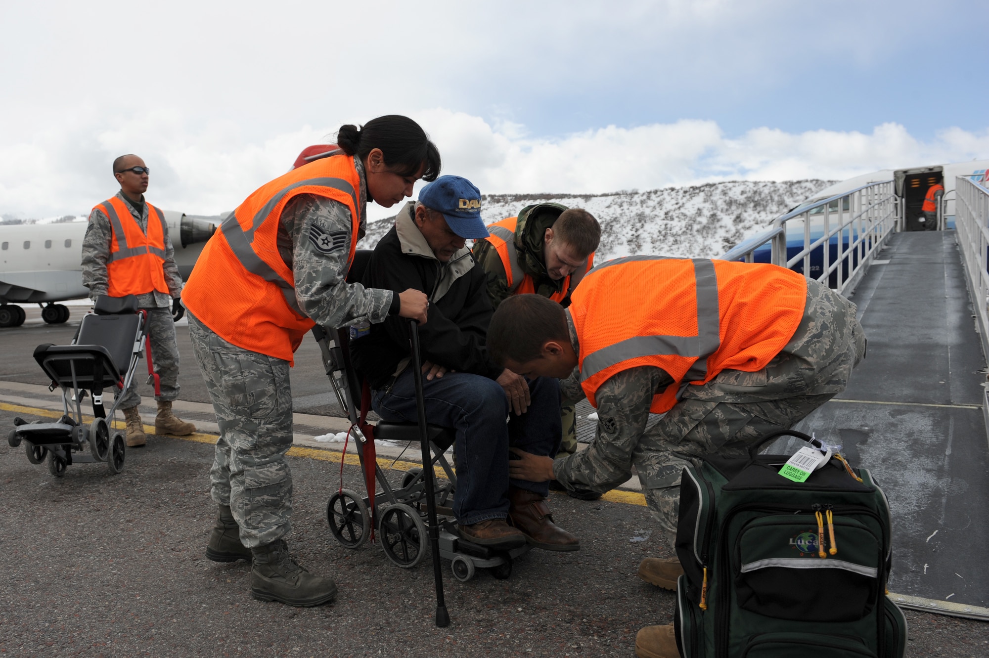 Staff Sgt. Audrey Delong, Tech. Sgt. Dennis Leskovec and Airman First Class Taylor Quintero help a veteran into a wheelchair March 27, 2010, at the airport in Aspen, Colo. Veterans were arriving from all over the world for the 24th National Disabled American Veterans Winter Sports Clinic.  The three volunteers from Luke Air Force Base, Ariz., were there to assist veterans arriving for the games. (U.S. Air Force photo/Staff Sgt. Desiree N. Palacios)