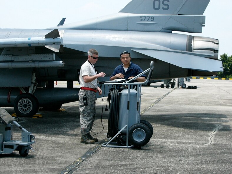Tech. Sgt. Craig Souza, left, and Senior Airman Michael Casarez, both 51st Aircraft Maintenance Squadron, go over paperwork during exercise Commando Sling 10 operations at Paya Lebar Air Base, Singapore. (Courtesy photo)