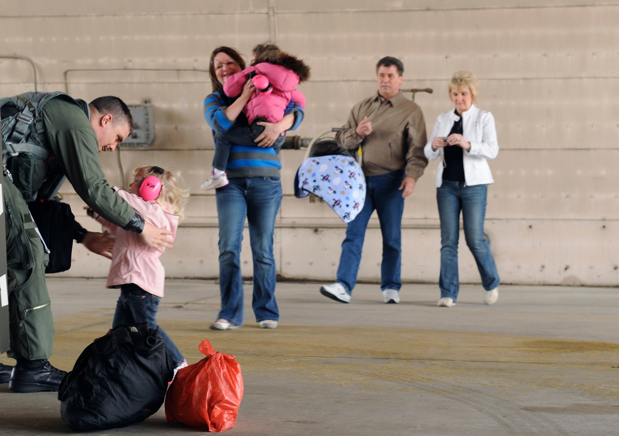 Members of the Brown family greet their father, husband and son, Capt. Aaron Brown, as he returns to Osan Air Base, Republic of Korea, March 15. Captain Brown, a 36th Fighter Squadron pilot, returned from Paya Lebar AB, Singapore, where he participated in exercise Commando Sling 10. (U.S. Air Force photo/Senior Airman Stephenie Wade)